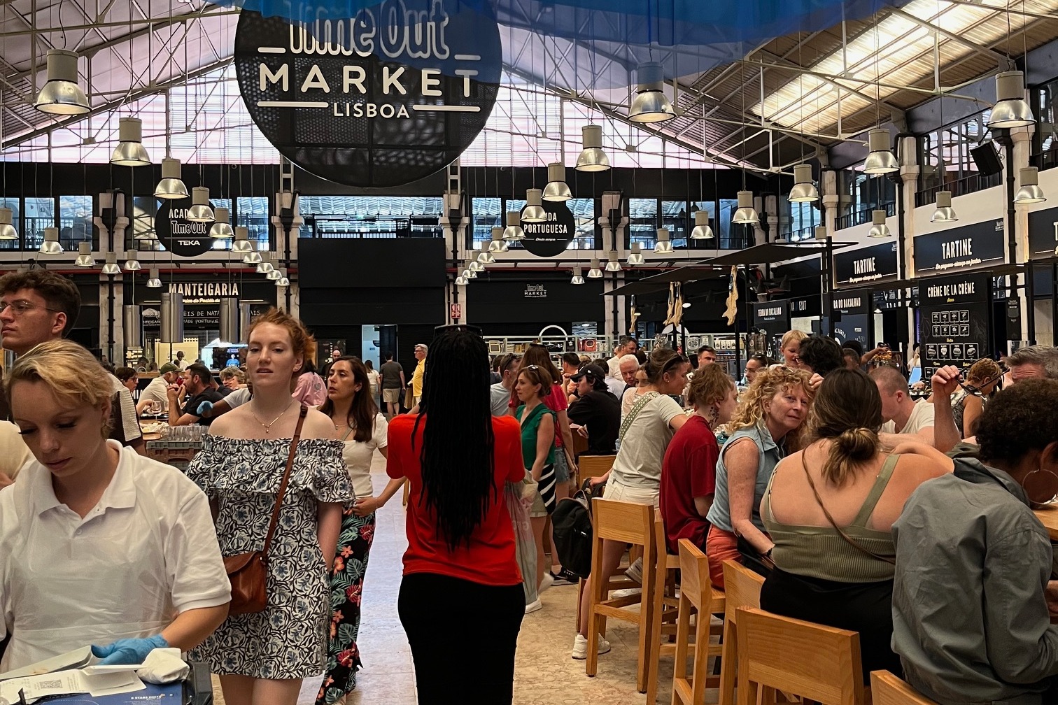 A large industrial space with a large amount of people sitting and dining