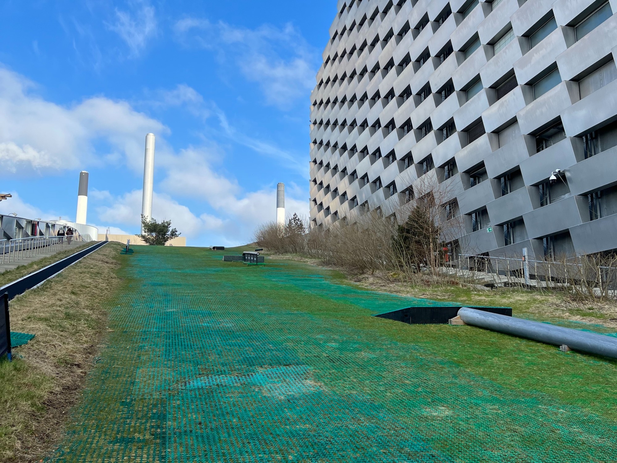 Green turf on the ground in front of a geometric building