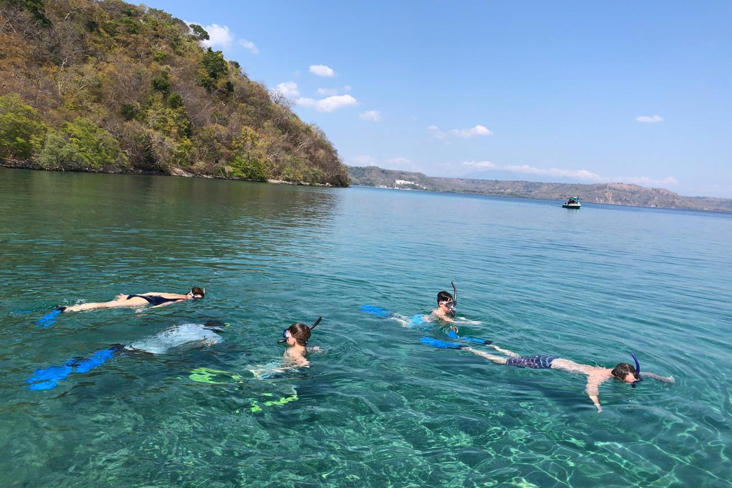Enjoy swimming at the beach as tourists snorkel of the coast on a sunny day.
