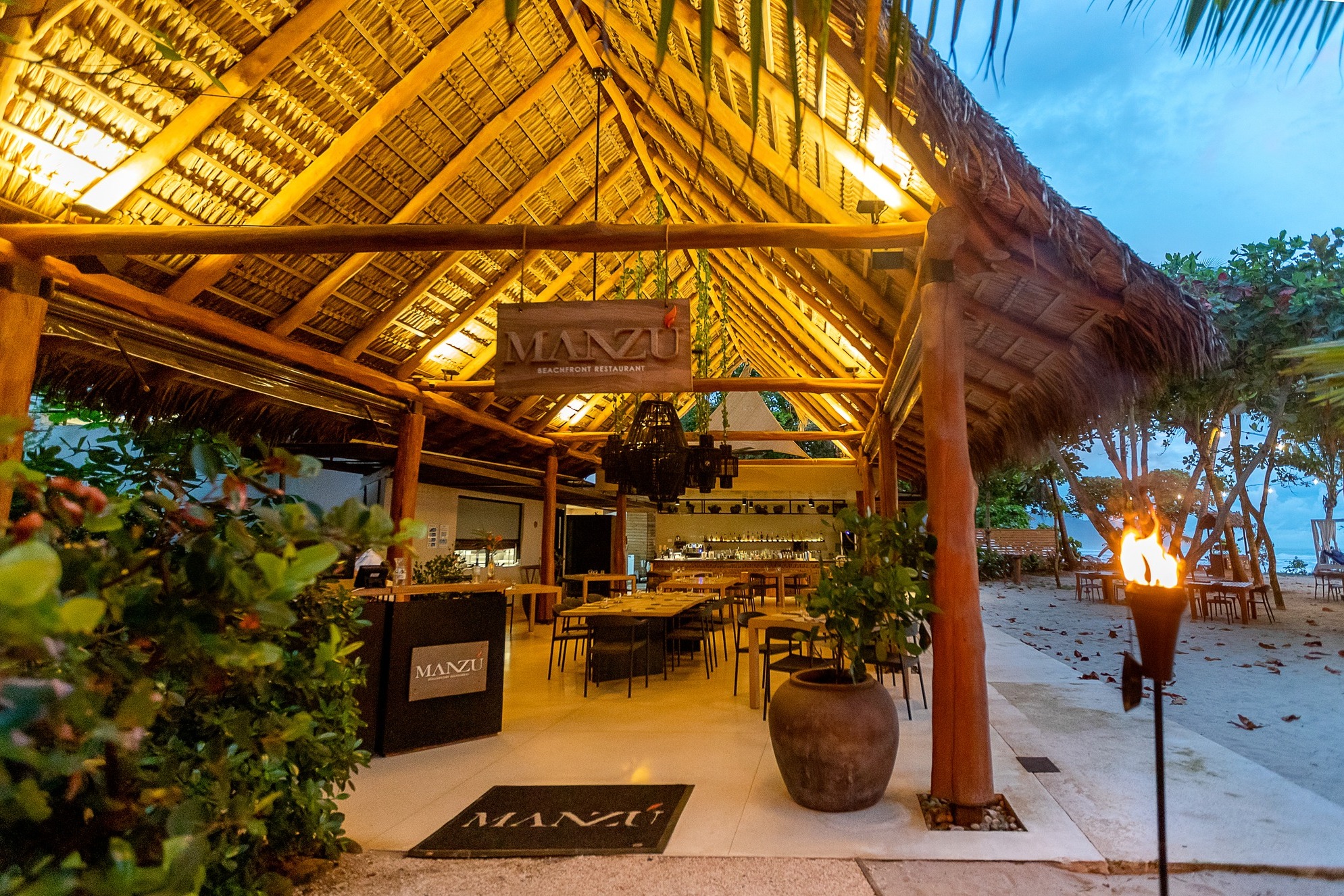 Dine at Manzu, that sits beachfront at sunset.