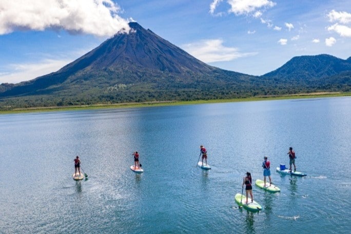 A group of people paddle boarding in Culebra Bay on a sunny day.