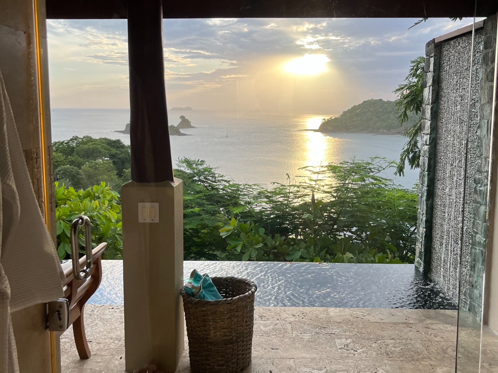A view from Casa Chameleon hotel room, overlooking the ocean and forest as the begins to set.