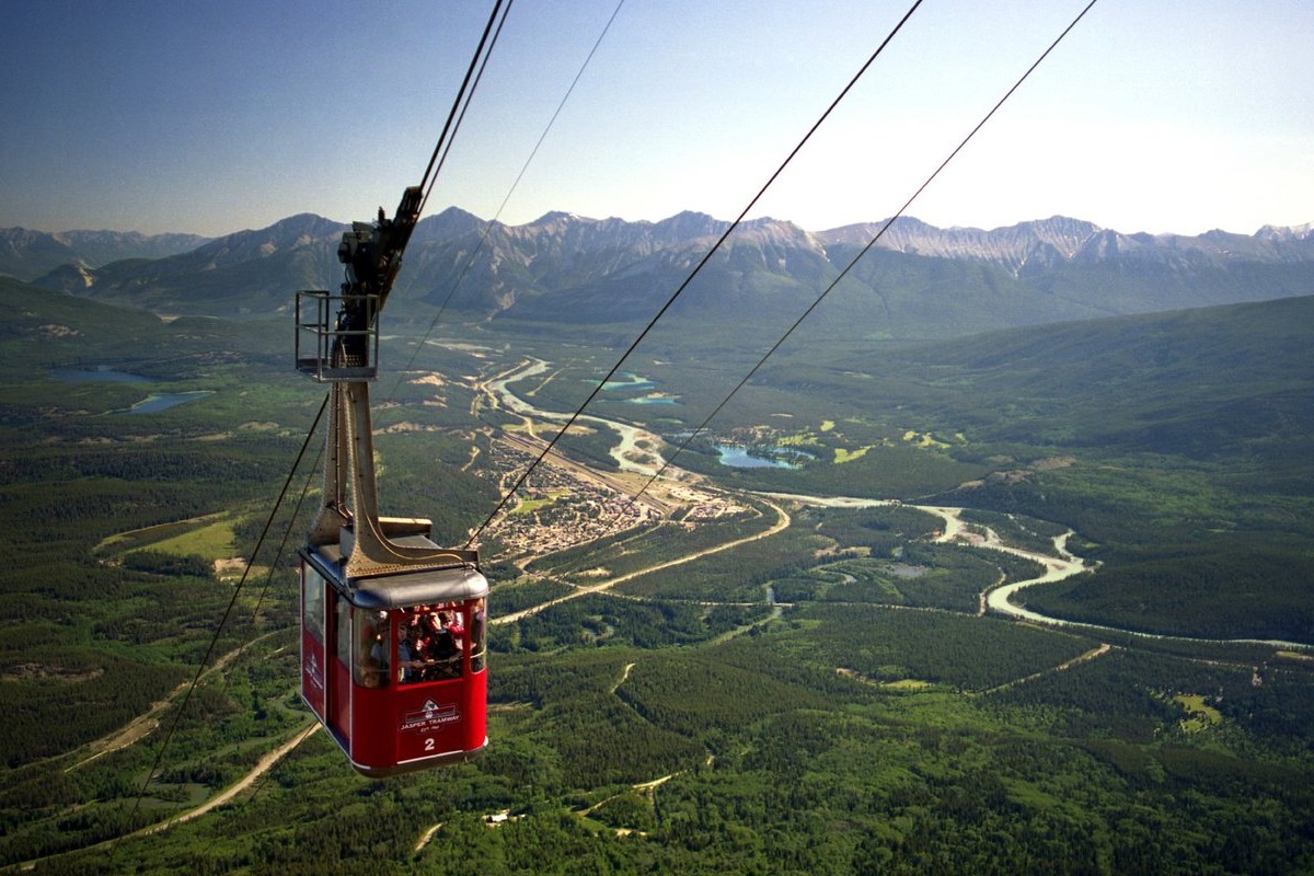 Take the Whistler Sky Tram to explore the beautiful landscape as a car scales the mountain terrain on a sunny day.