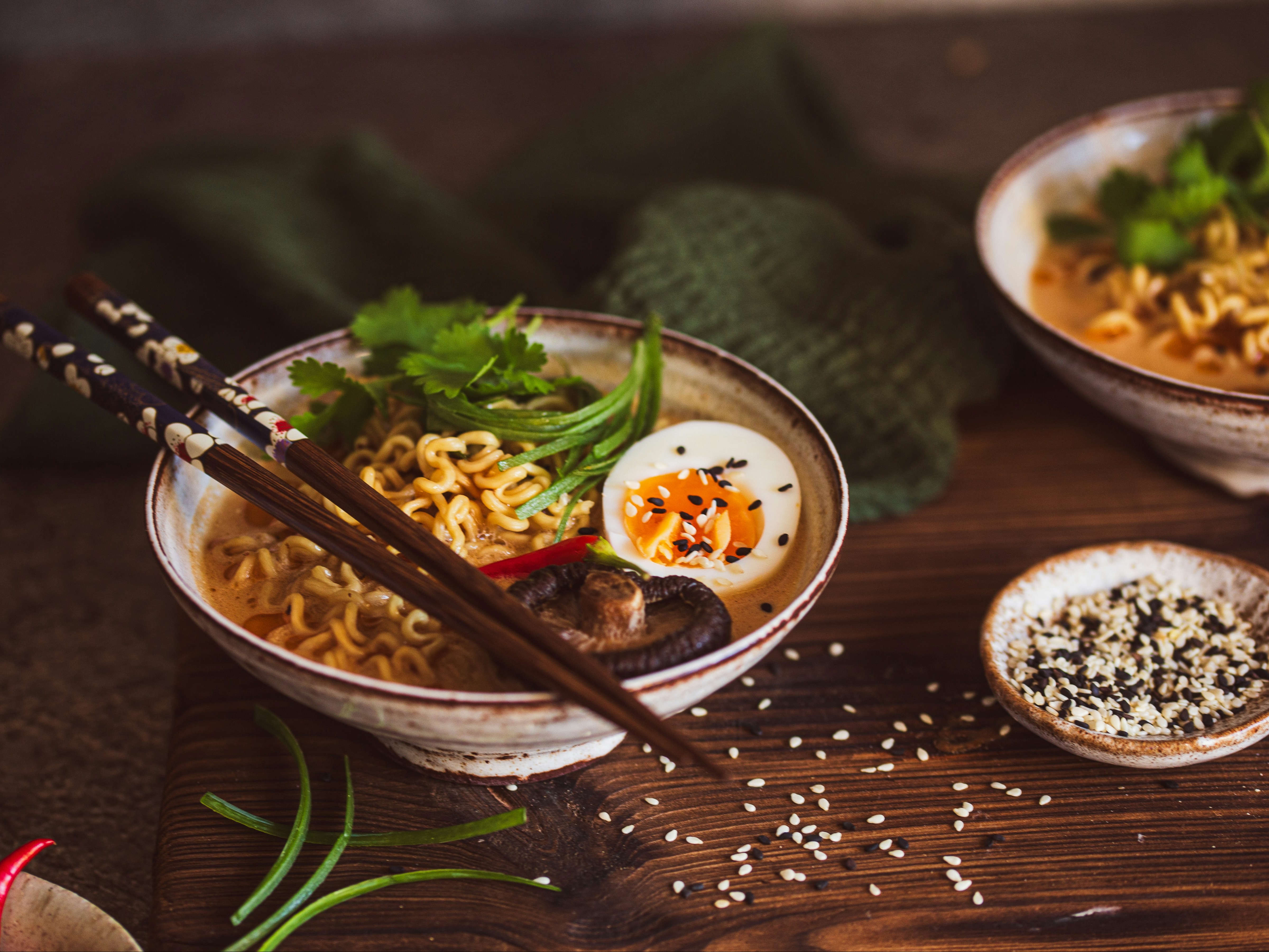 A bowl of ramen with toppings and chopsticks resting on top.