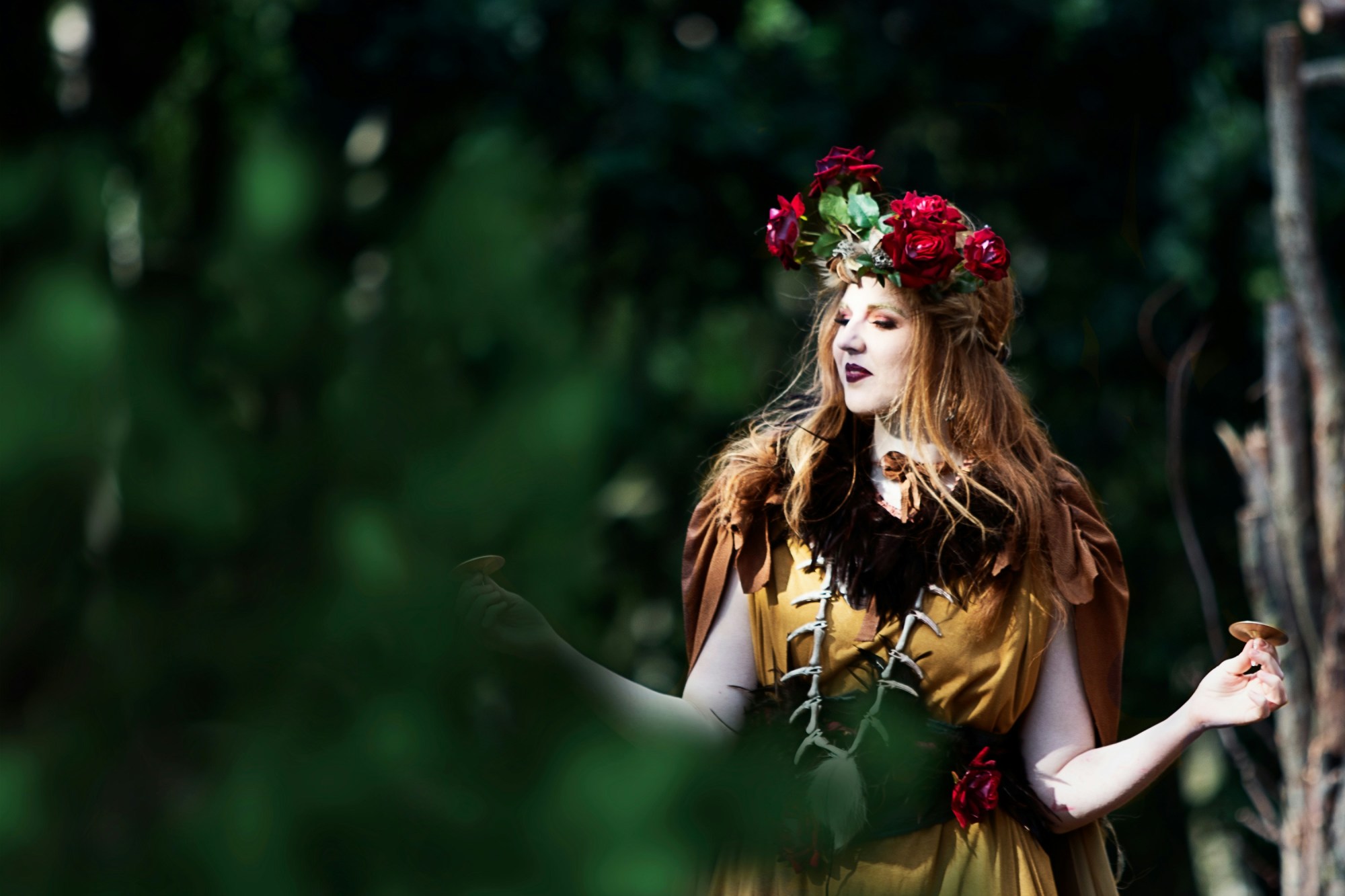 Woman wearing a brown dress and flower crown and dancing.