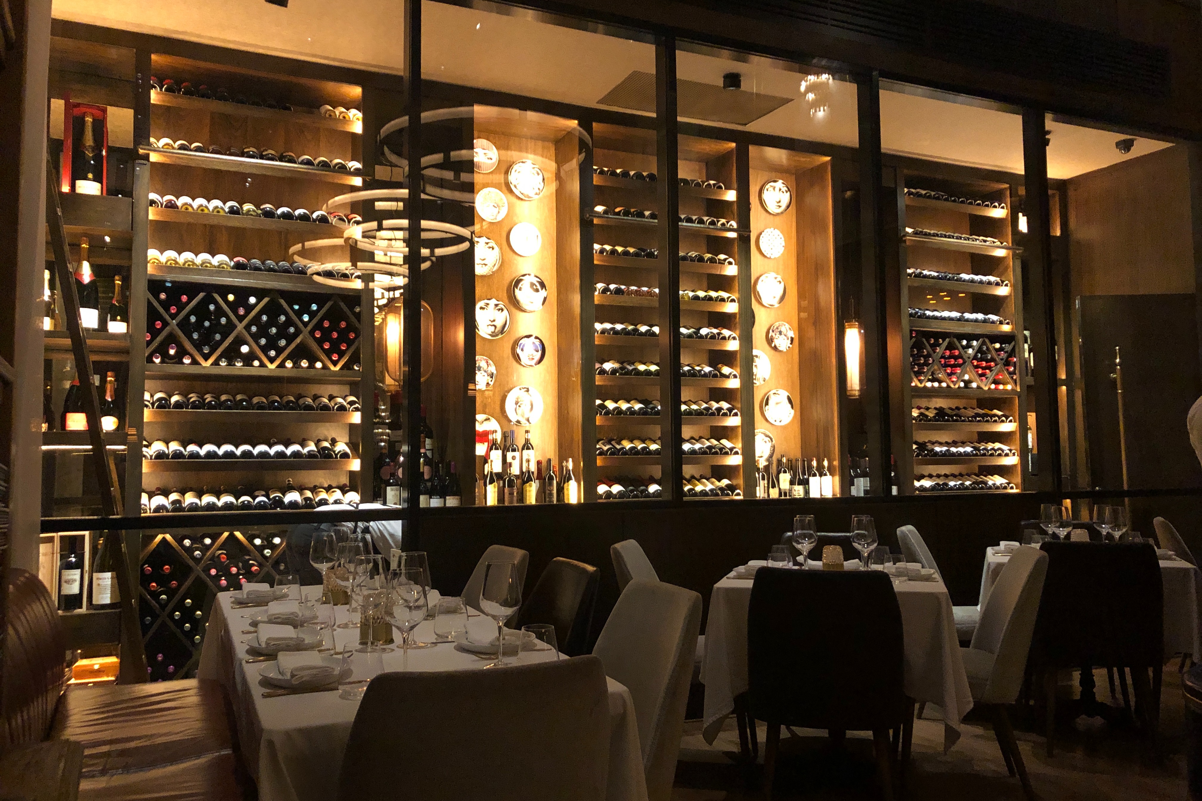 A dimly lit view of a restaurant and its extensive wine selection at El Meson De La Cava.