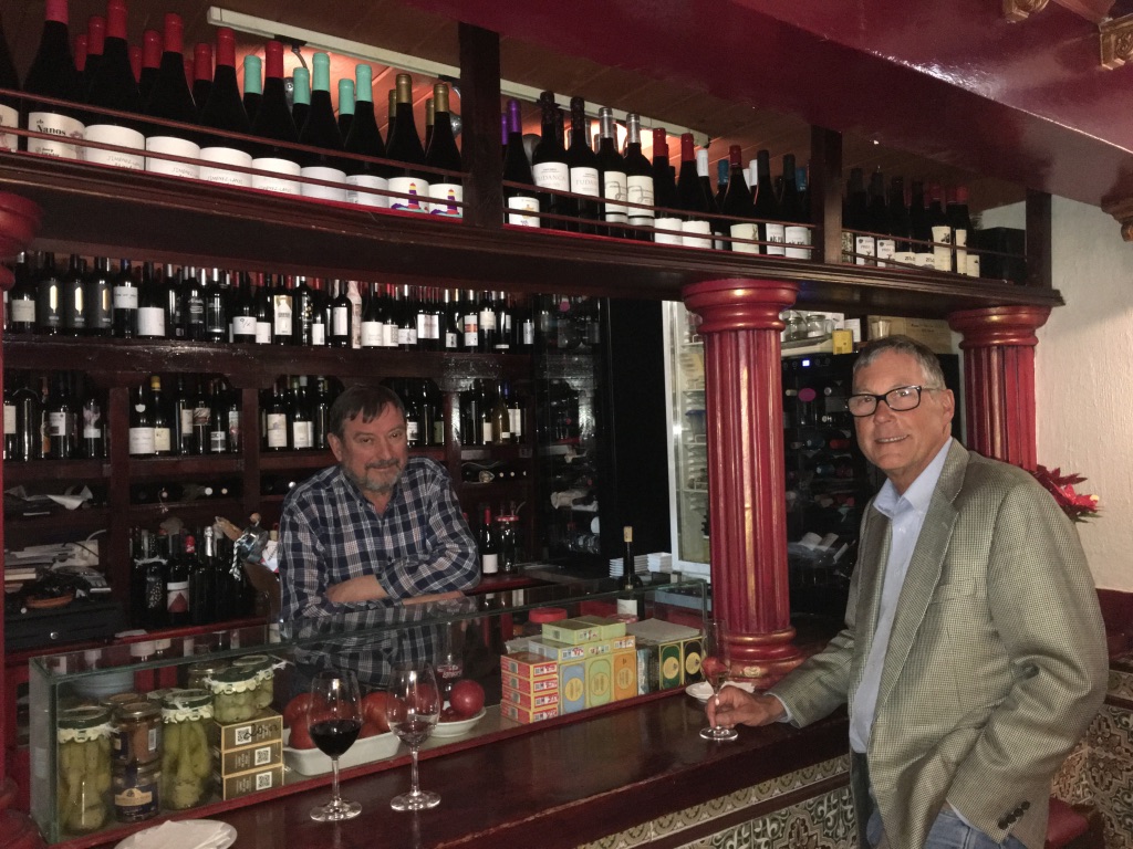 Two men posing at bar counter.