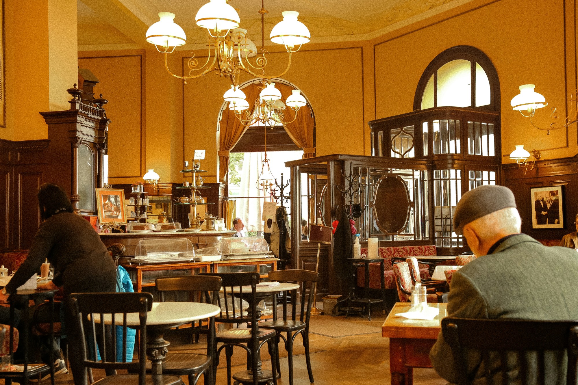 People sitting in a café with warm lights.