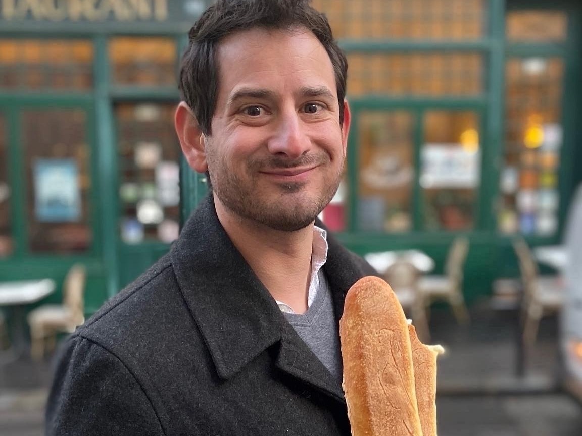 A man holding a baguette.