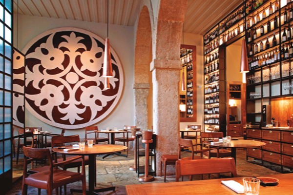 Dine at Alma, a high end restaurant at Lisbon with rich wooden furnishings and modern lighting.