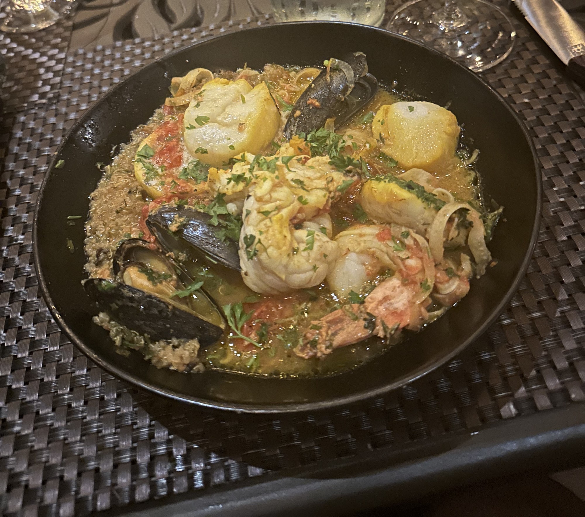 A hearty stew artfully plated in a lovely bowl on a patio table.