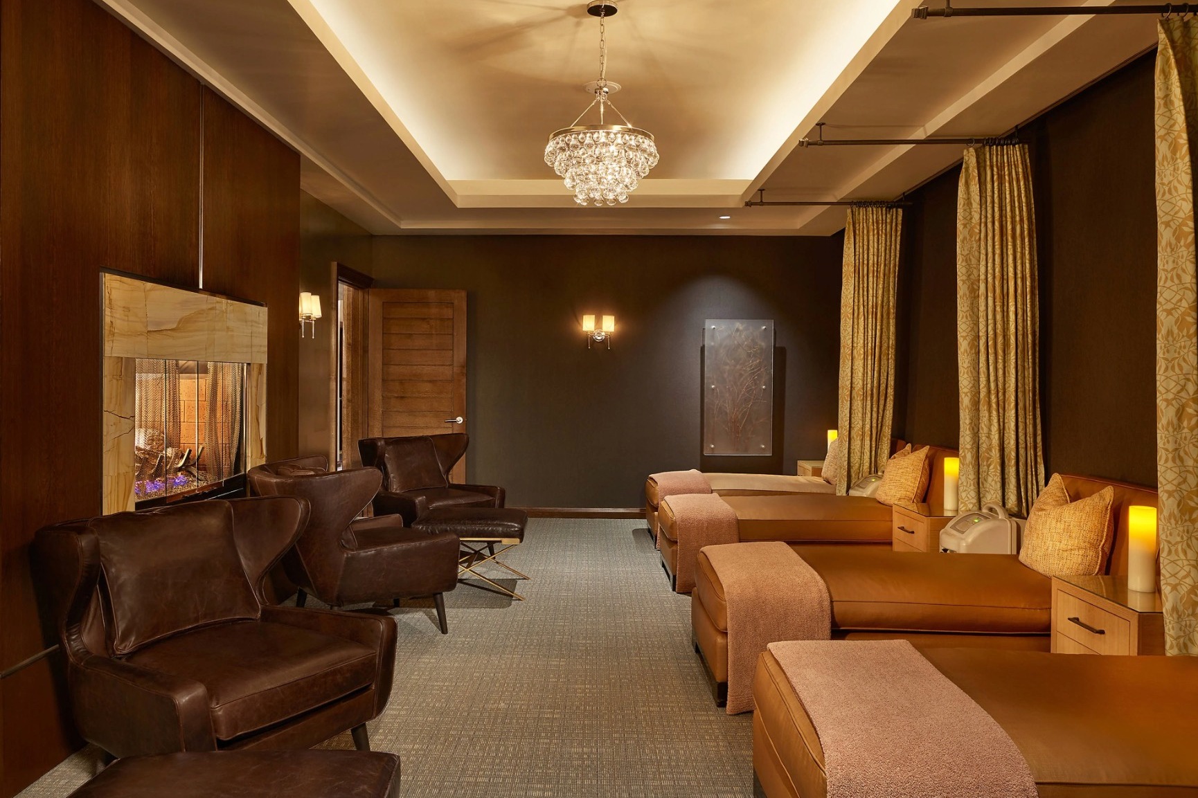 dark brown room with soft lighting, a chandelier and loungers