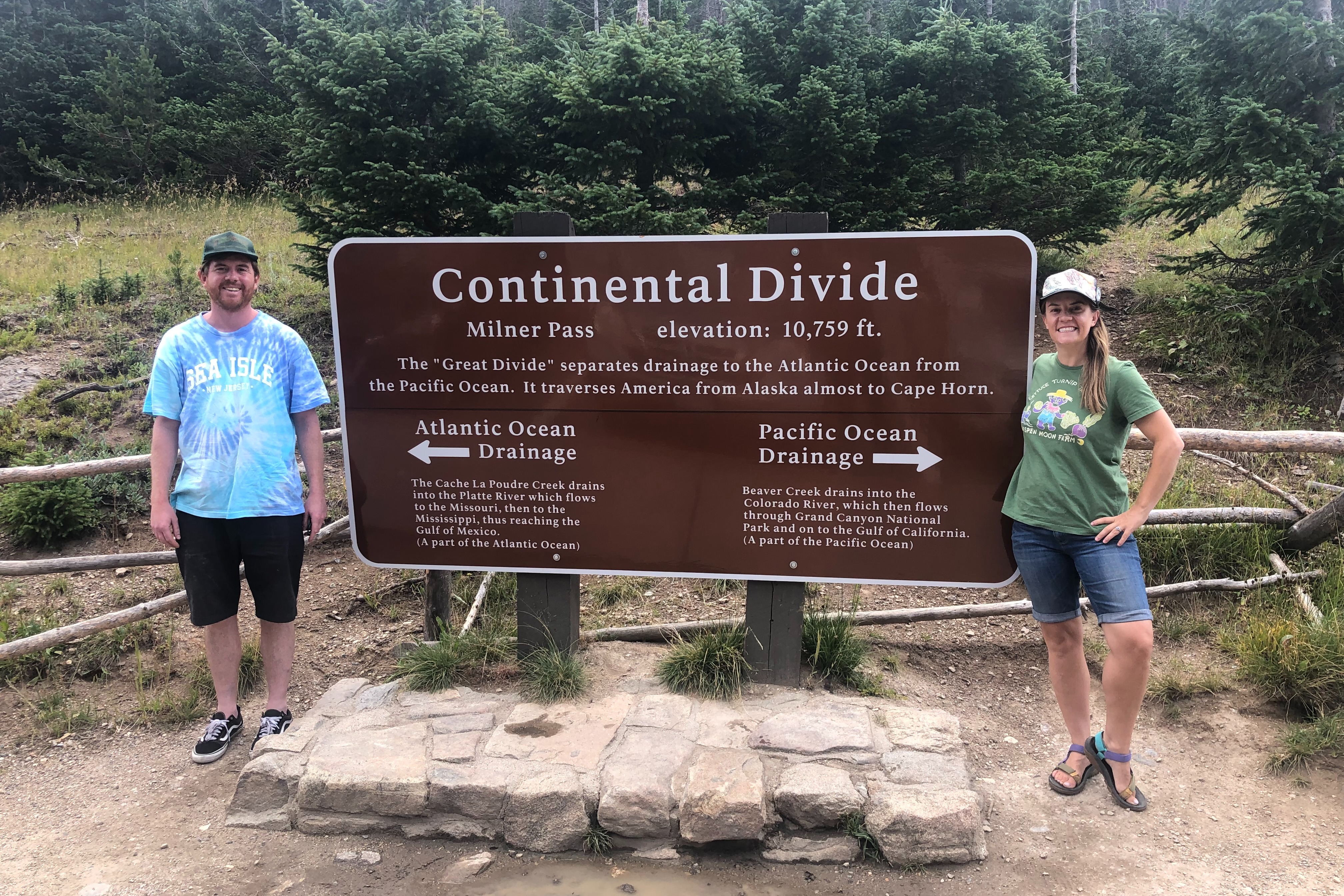 The advisor and her husband standing next to a Continental Divide sign.