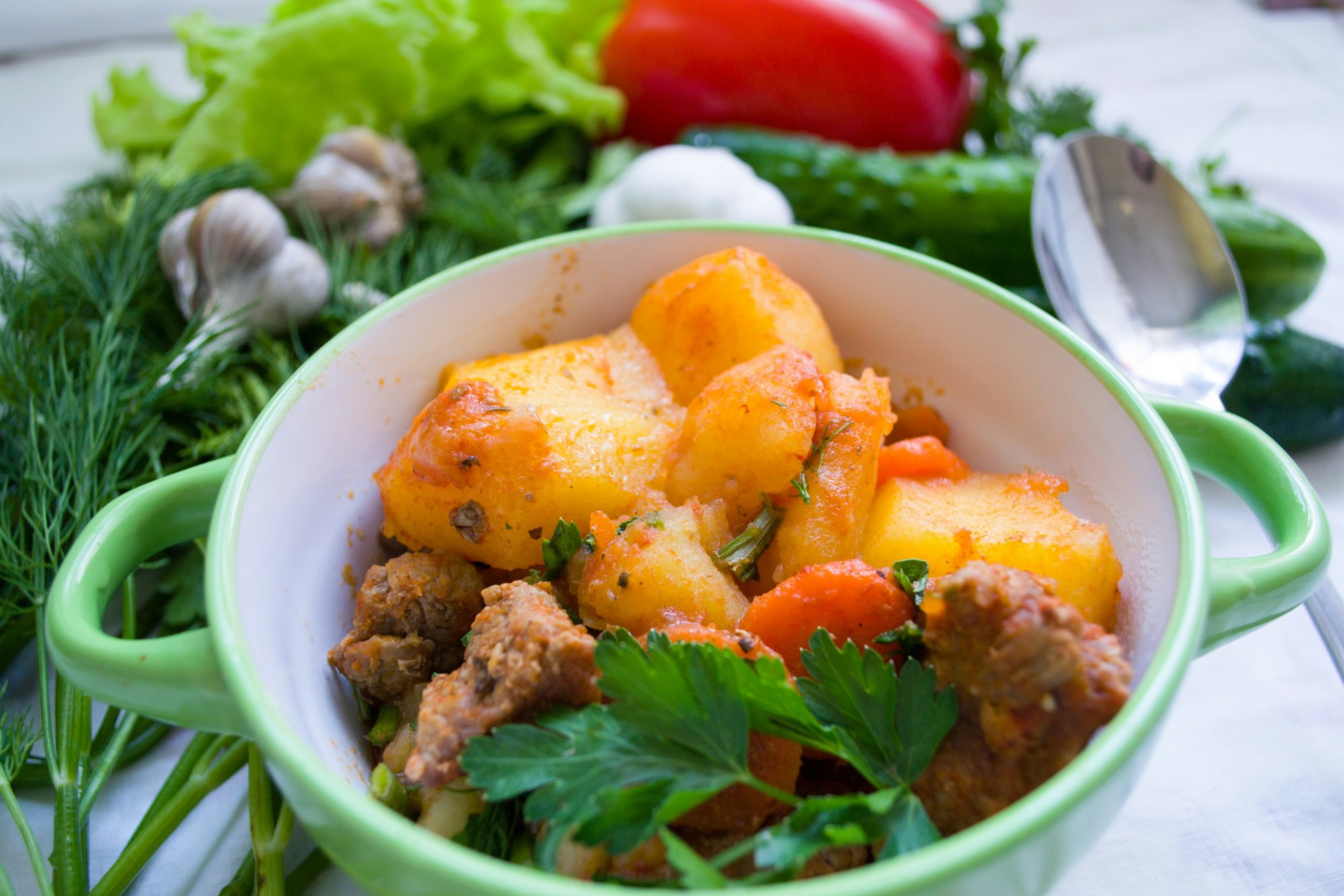 A small Dutch over with potatoes and carrots and meat.