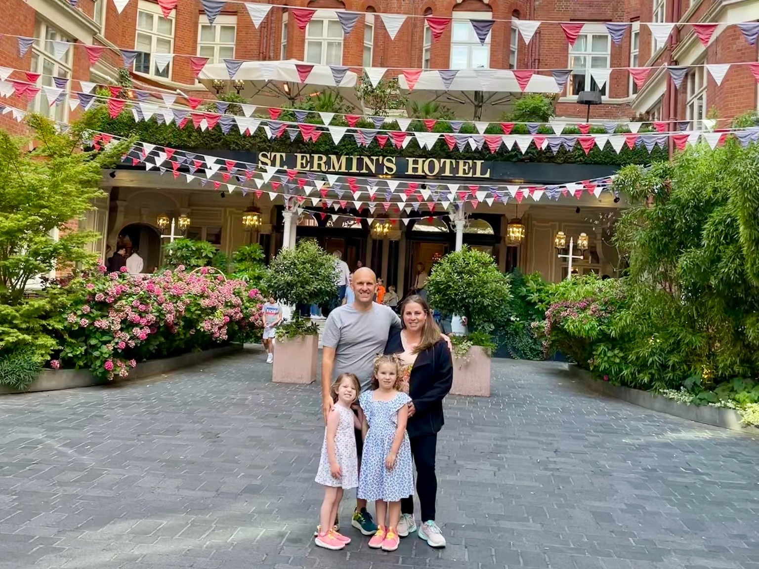 A family of four approaching the entrance of St. Ermin’s Hotel, adorned with British flags.