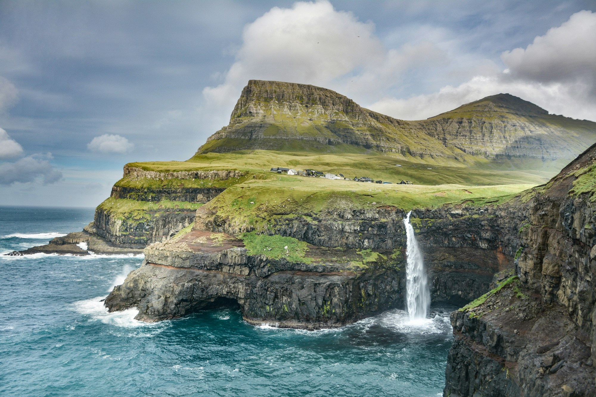 Waterfalls on mountains under nimbus clouds
