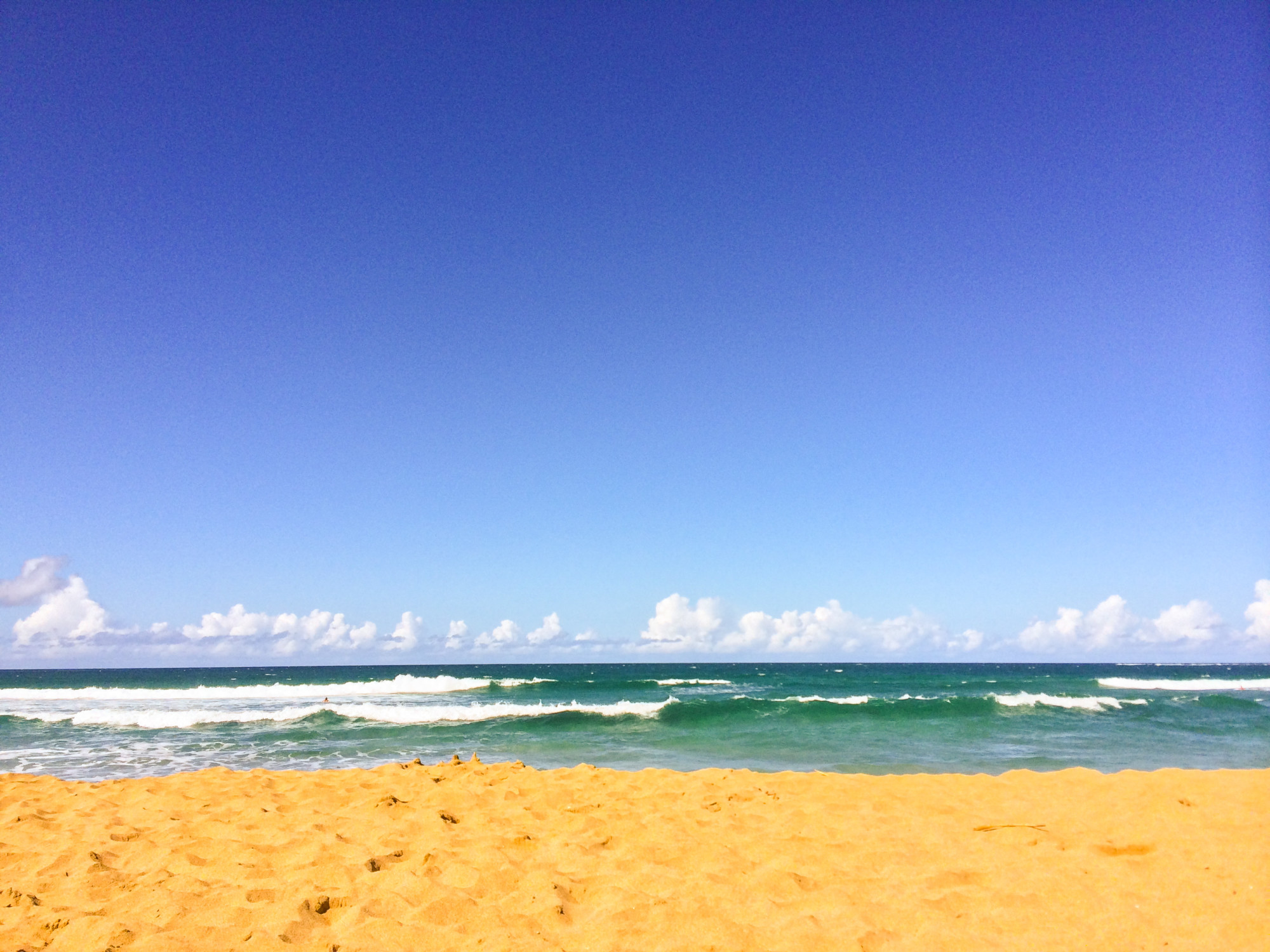 Sand and ocean in the background with waves rolling in.