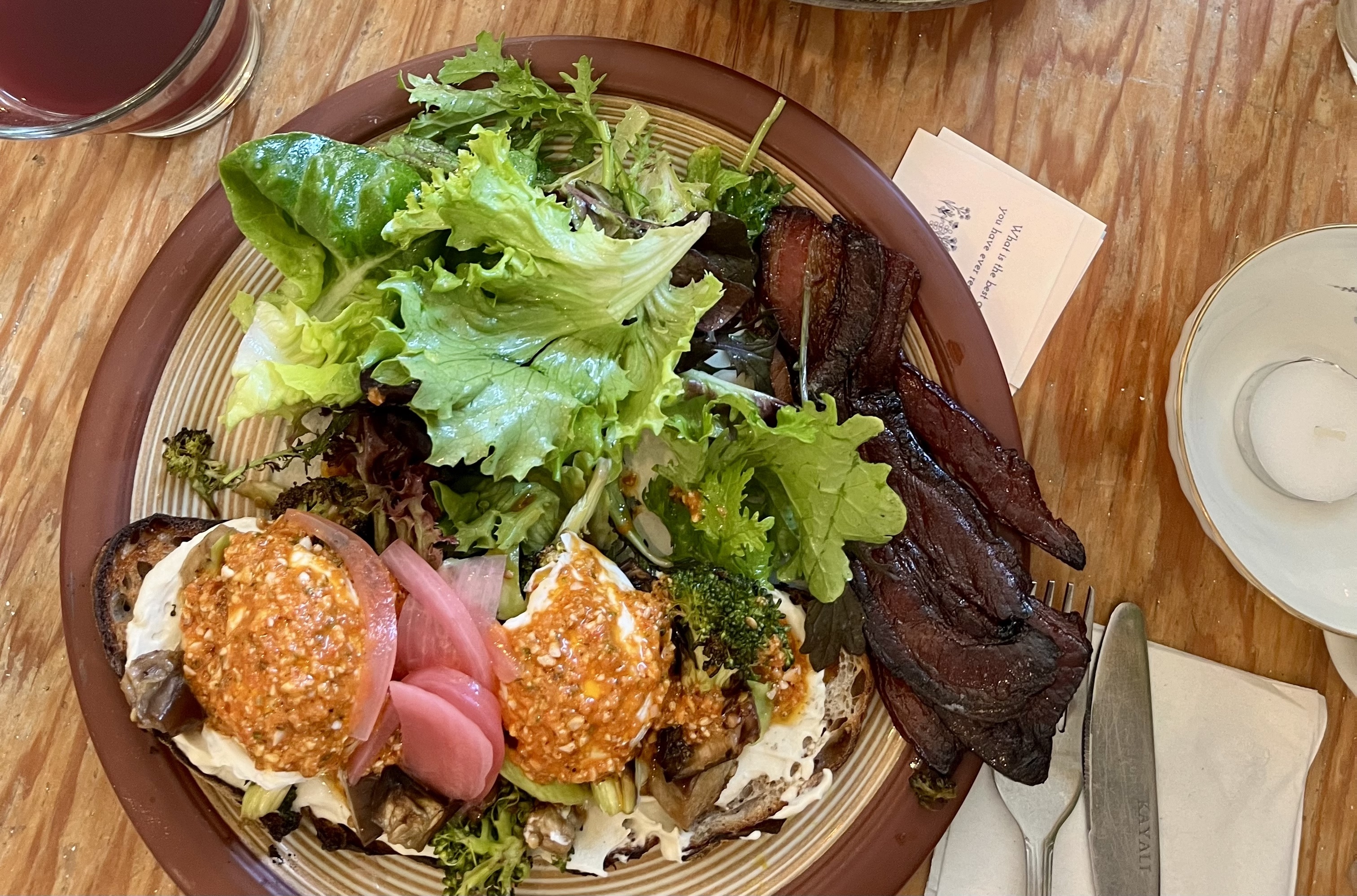 Healthy dish at Nourish Cafe artfully arranged on a plate set on a wood table.