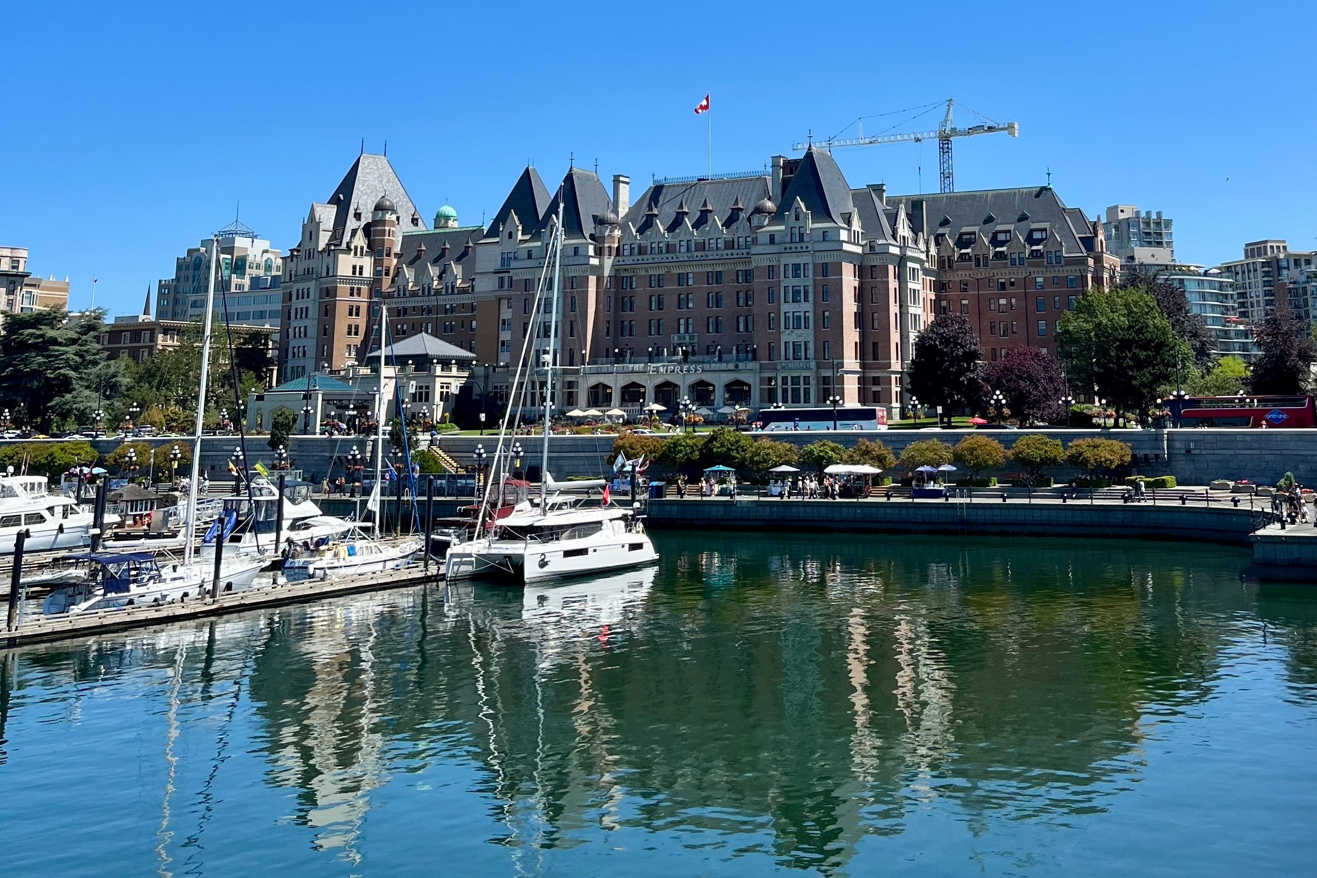 Ferries at Victoria Harbour dock along the pier on a clear, sunny day.