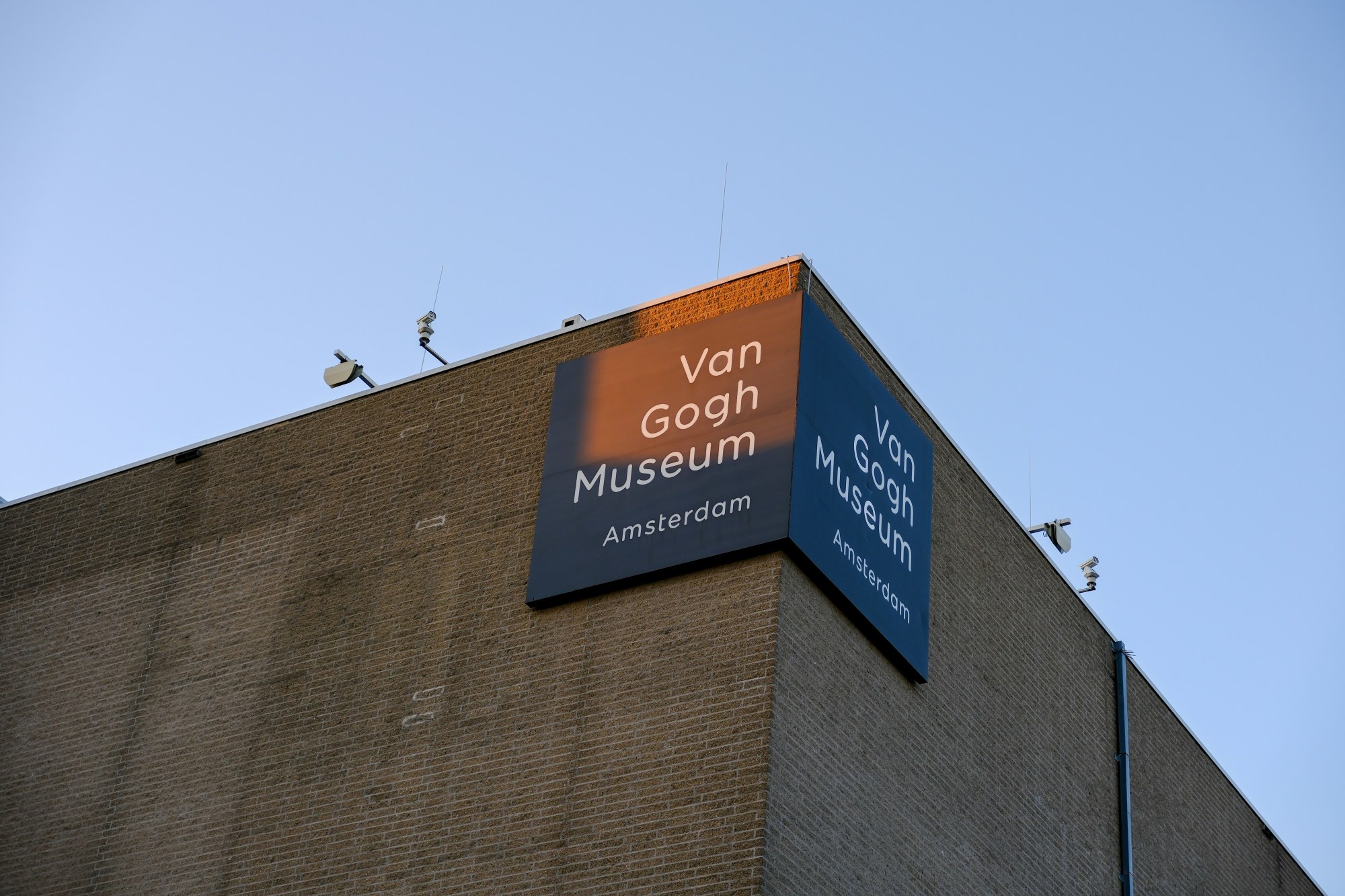 The Van Gogh Museum stands tall against a clear sky on a sunny day.