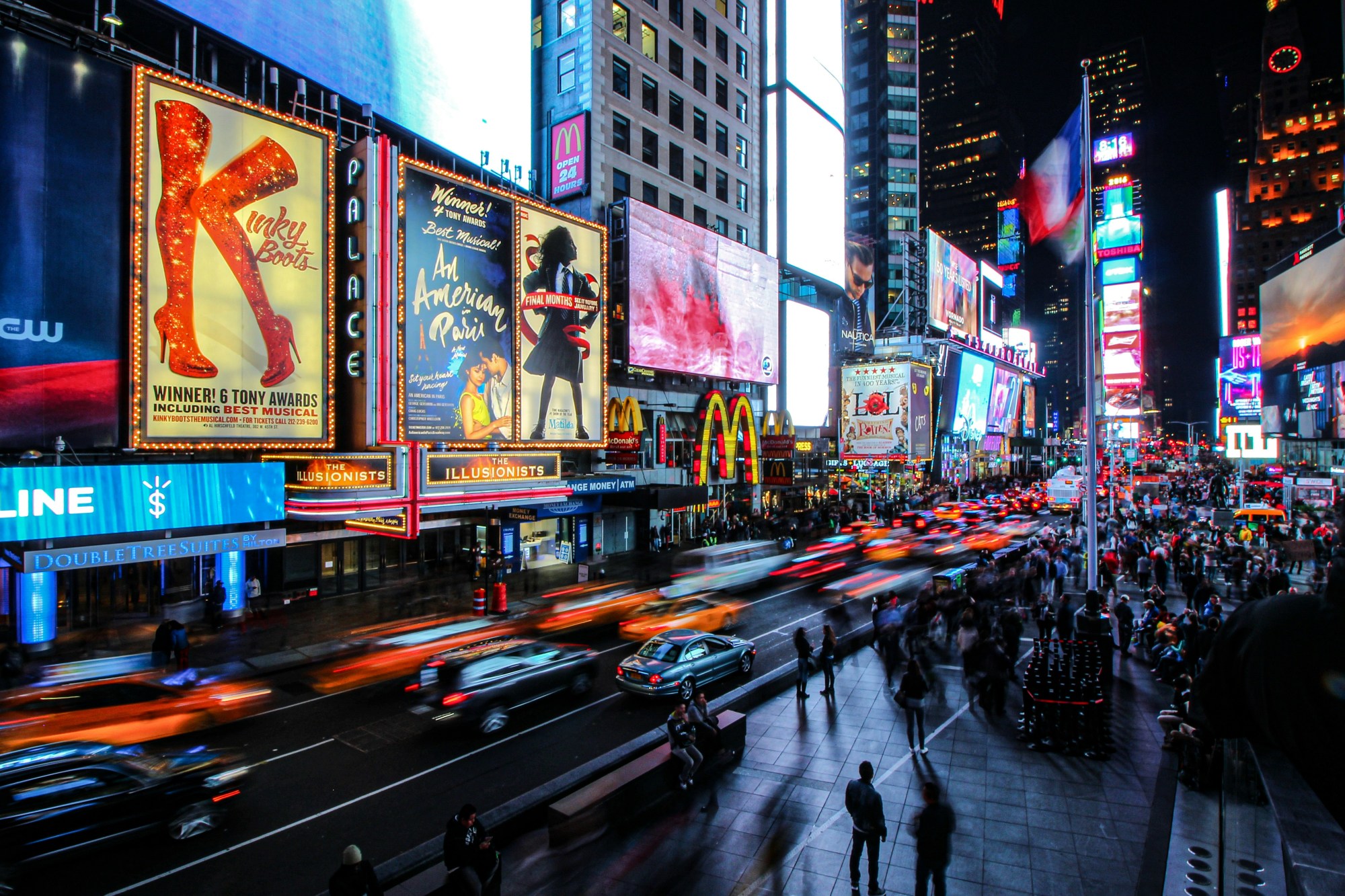 Times Square with colorful boards and screens at night.