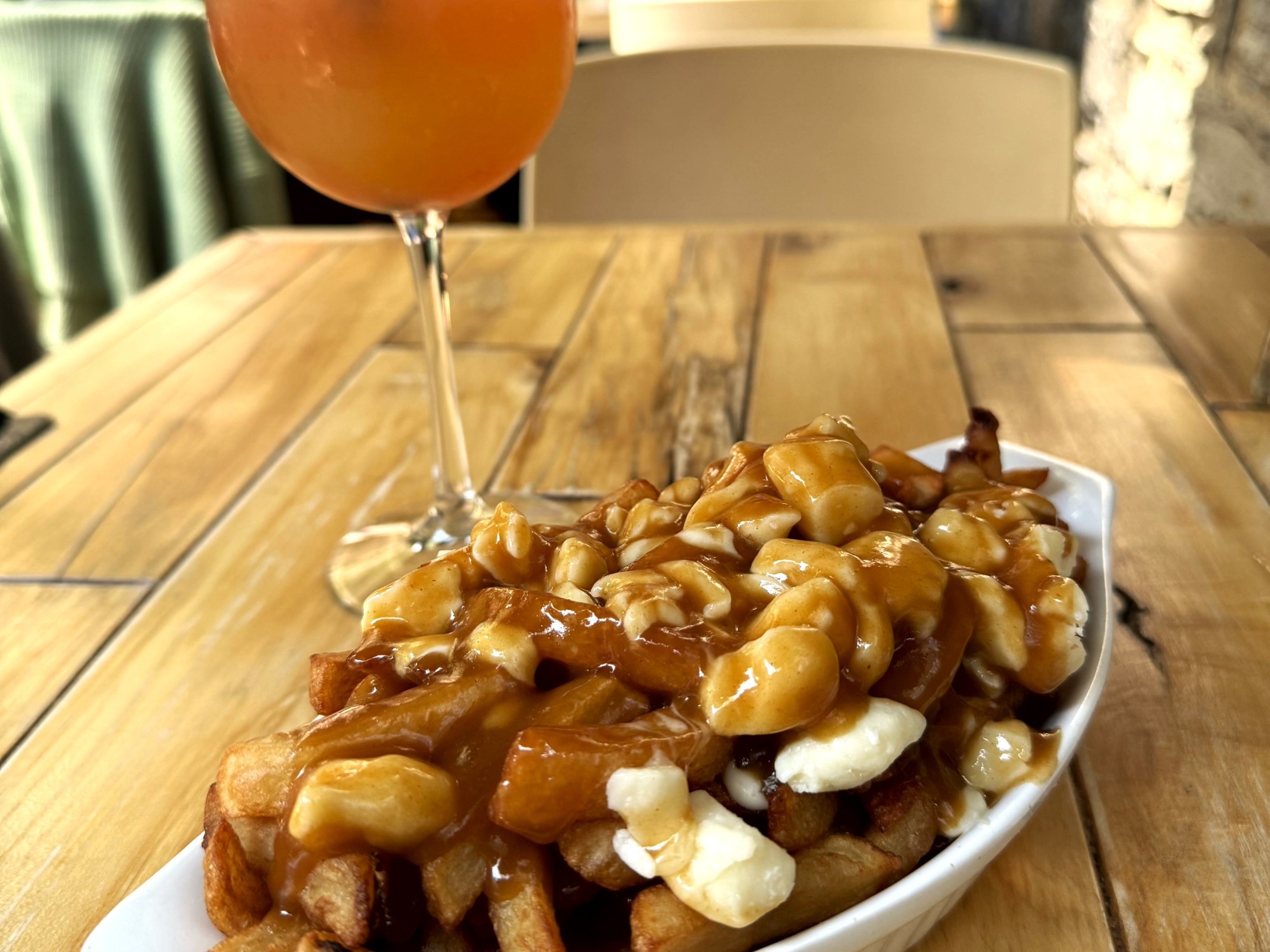 Loaded fries with drink on table.