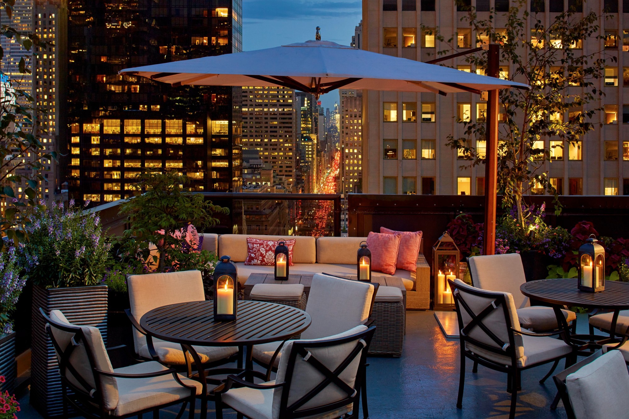 an outdoor dining terrace overlooking a city at night