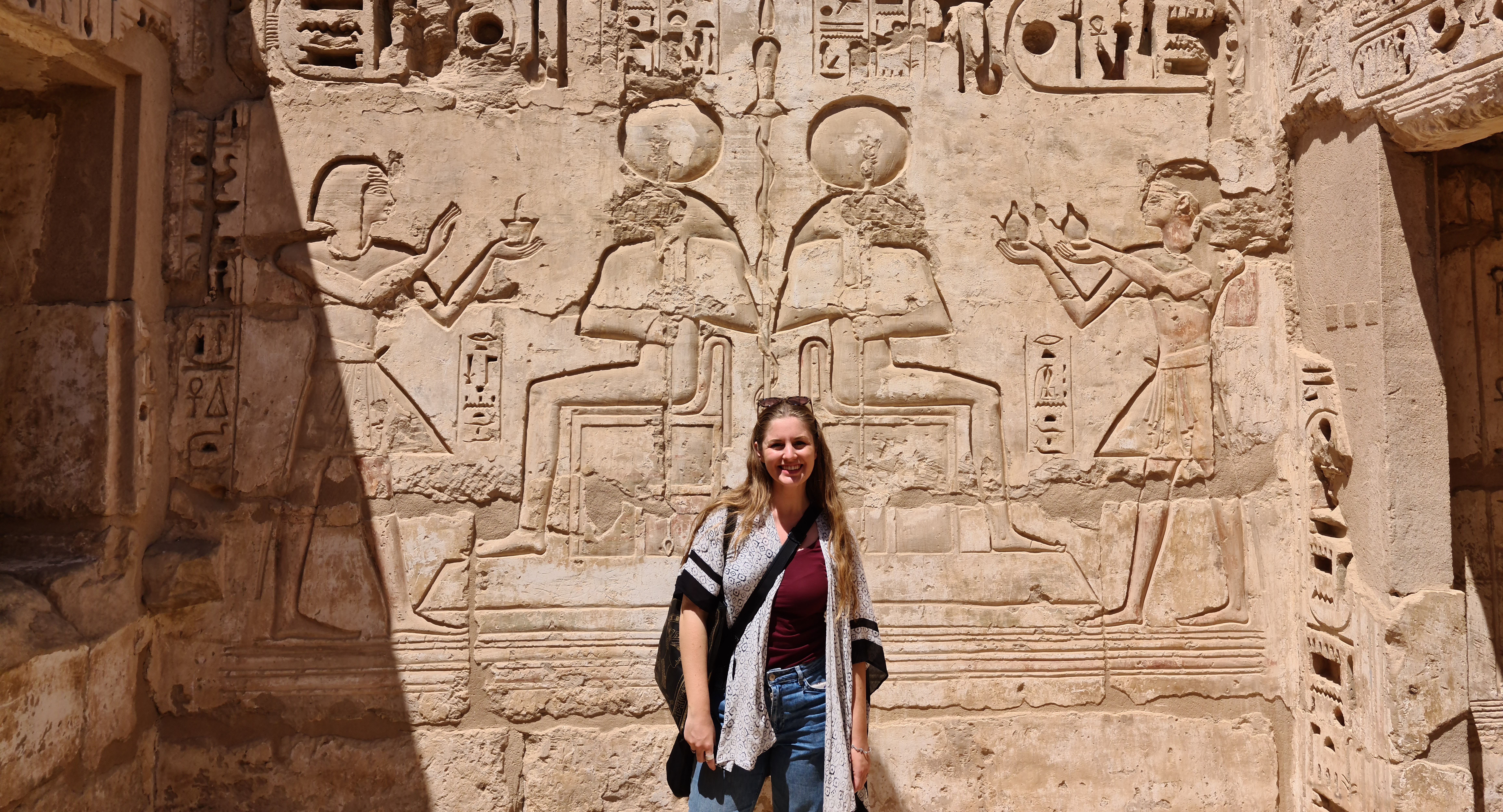 Advisor posing during the day time with ruins behind her.