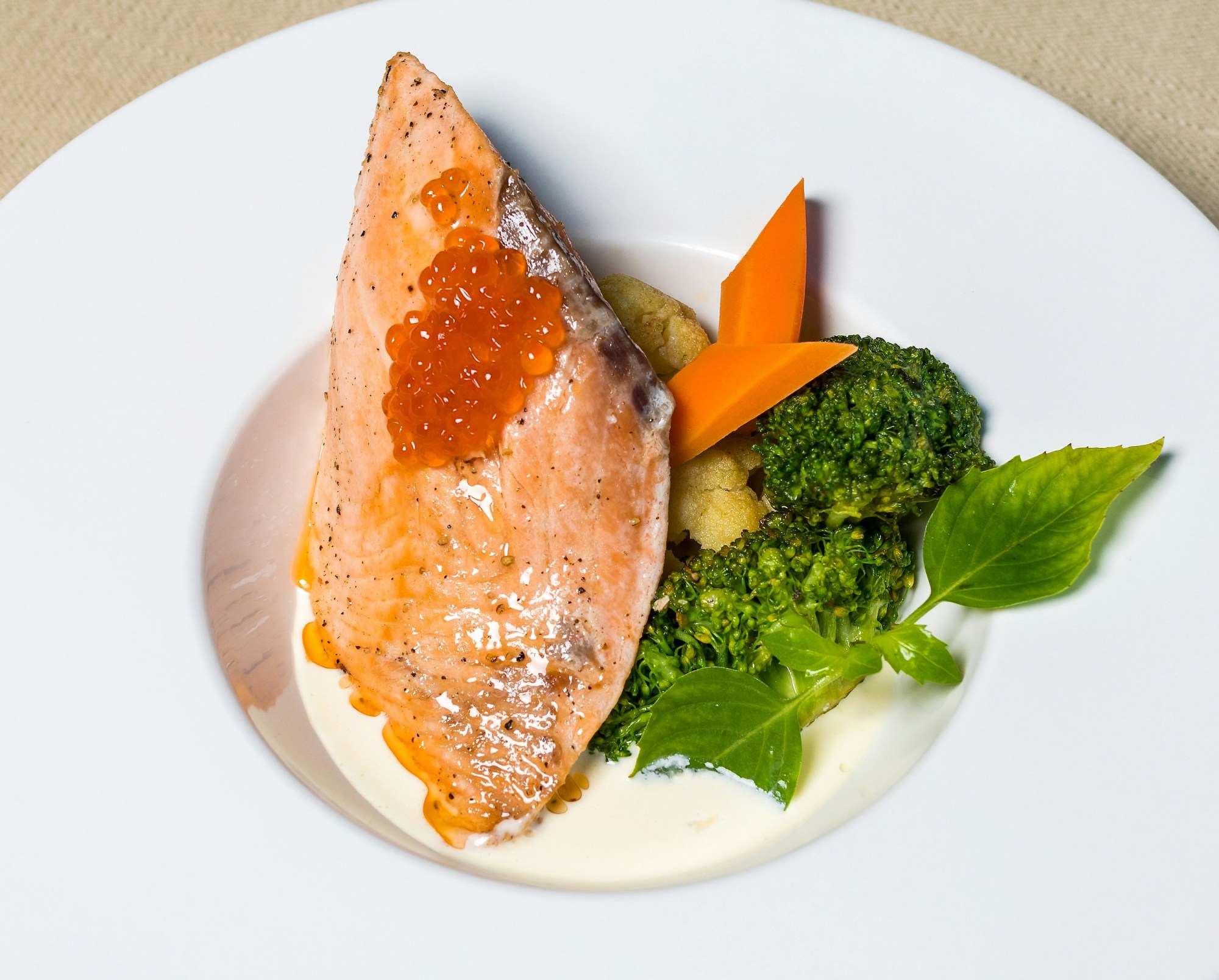 Salmon with vegetables on a white plate.