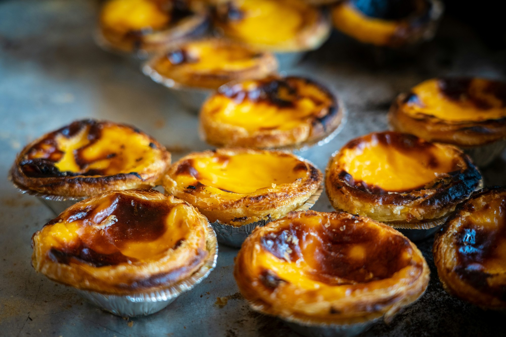 Tart pastries with golden edges cluster on a countertop.