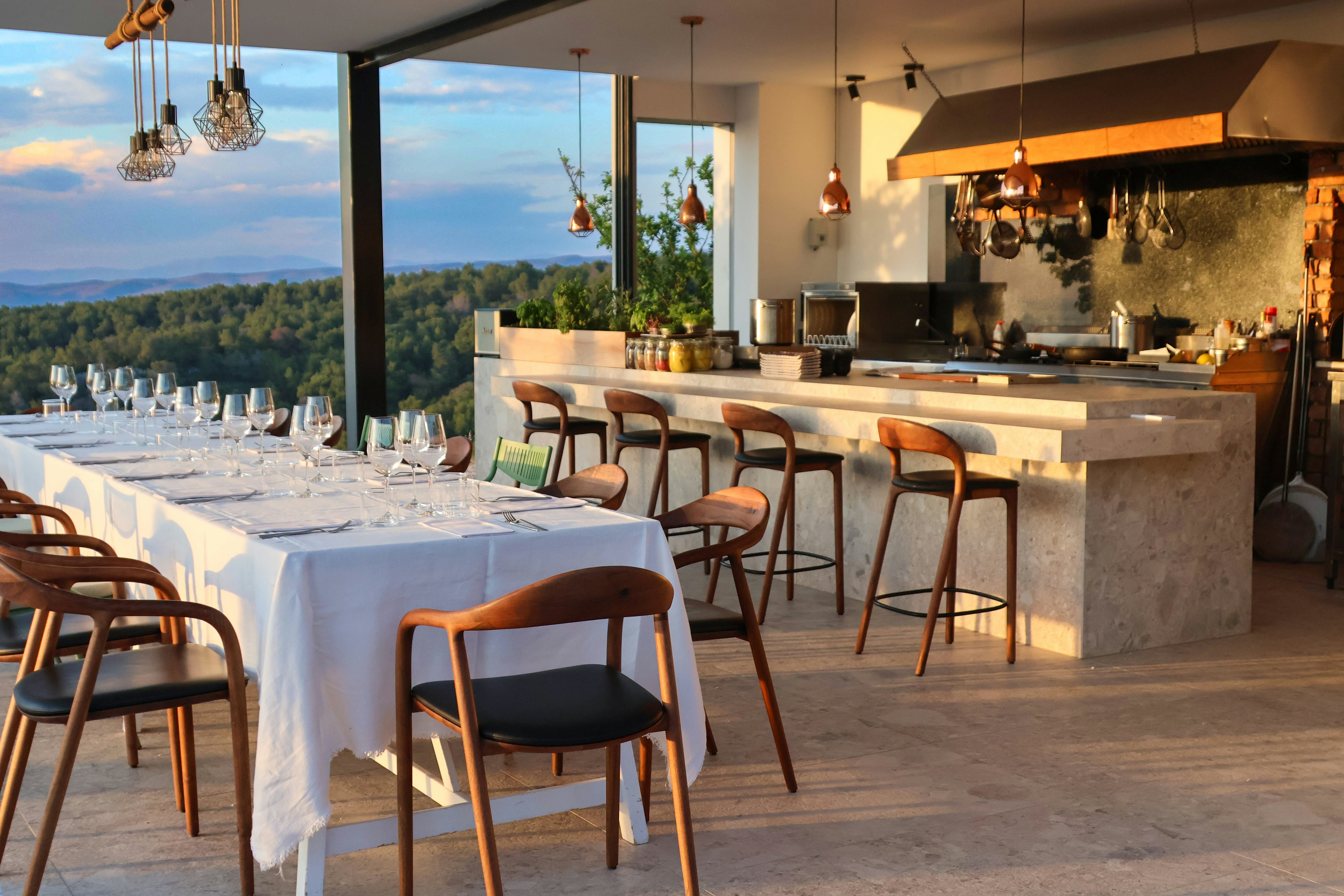 Outdoor dining on a roof terrace with a beautifully set table and bar area.