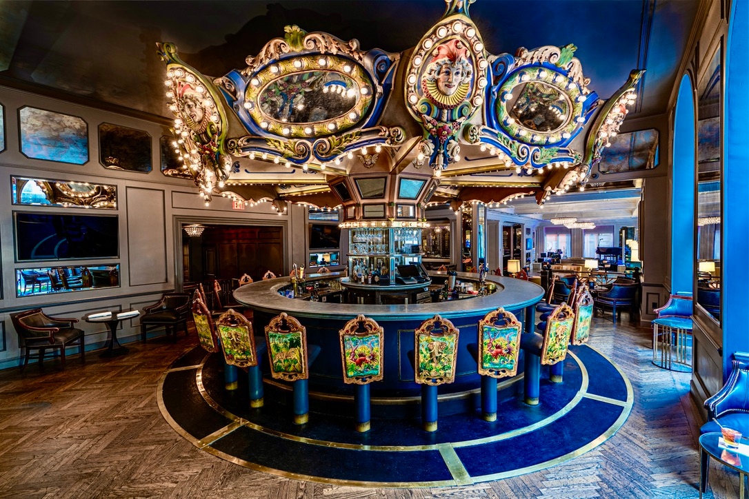 The famous Carousel Bar & Lounge in New Orleans covered in lights with revolving seats inside a well-lit lounge.