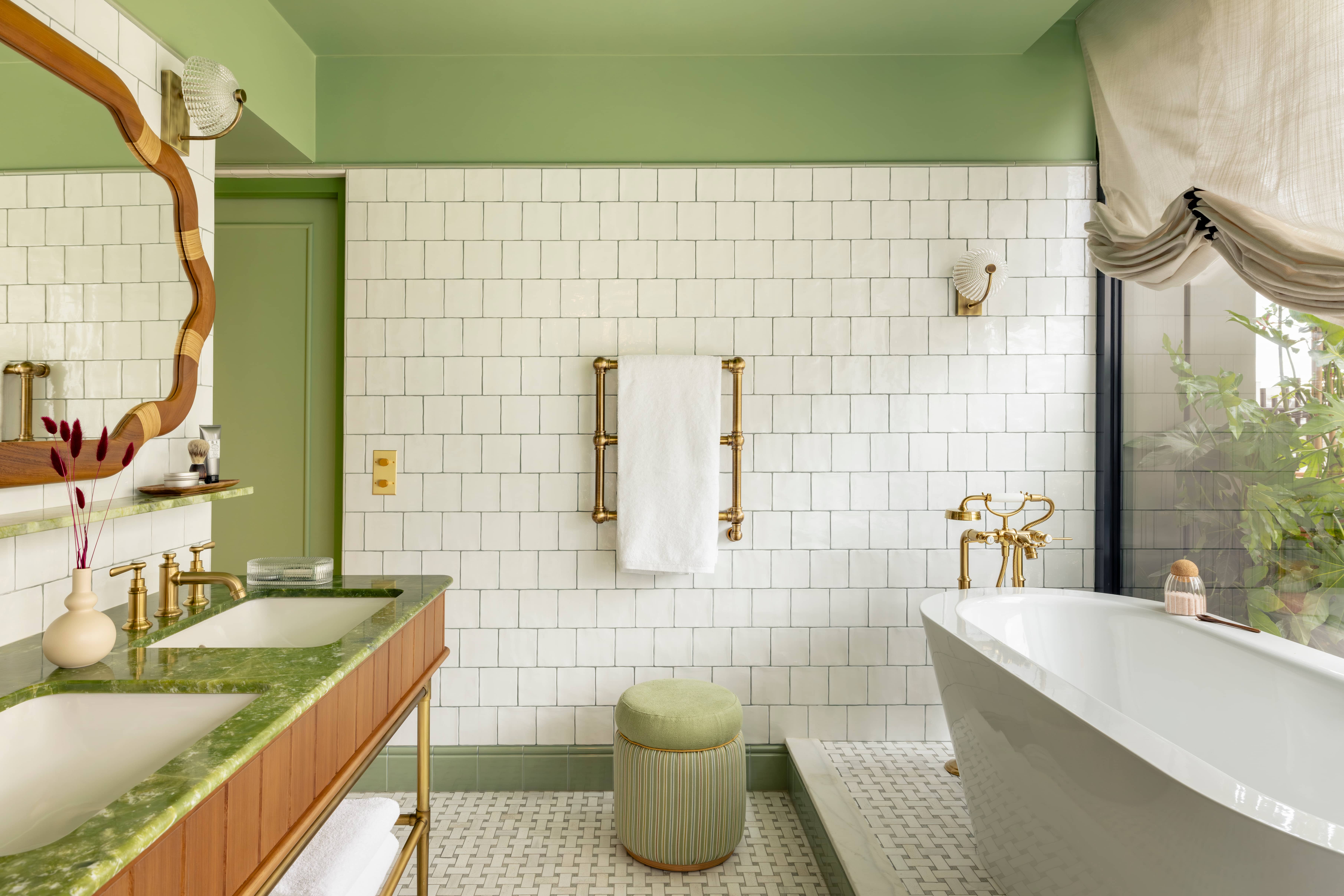 a fancy bathroom with green walls and a large white tub