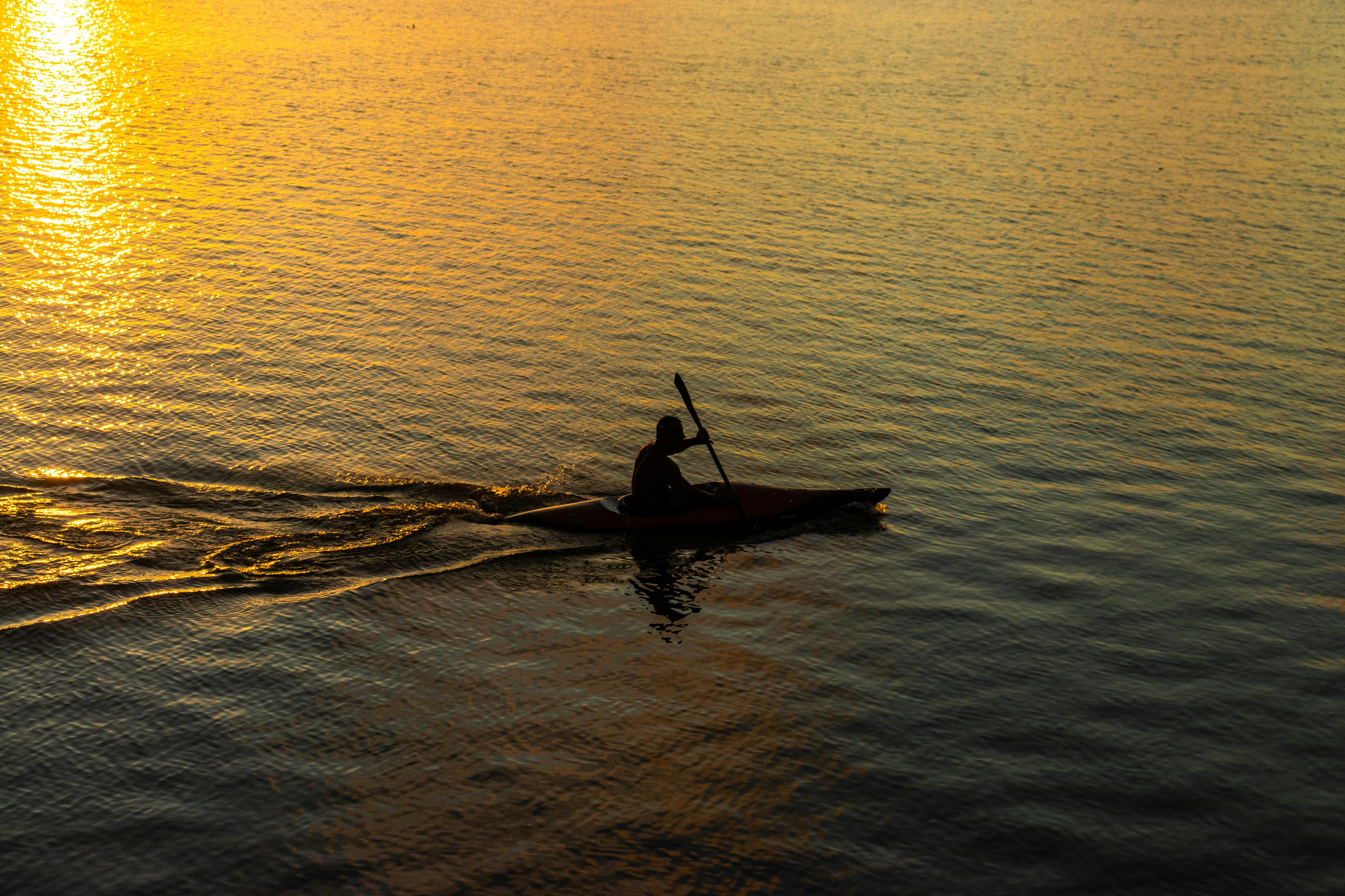 The image depicts a person enjoying paddleboarding in tranquil waters with a picturesque mountain backdrop.