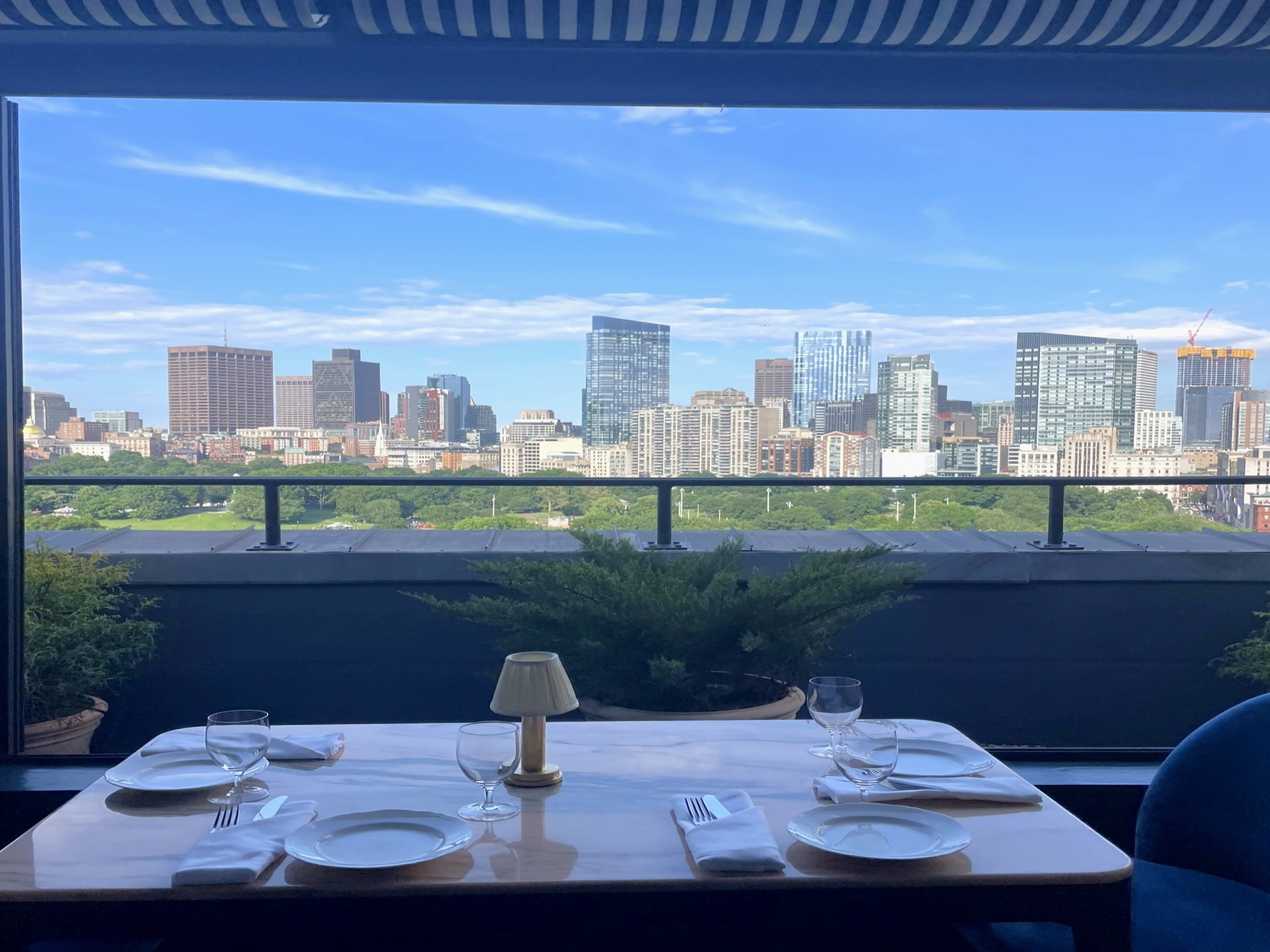 A table on an outdoor patio overlooking the Boston skyline.