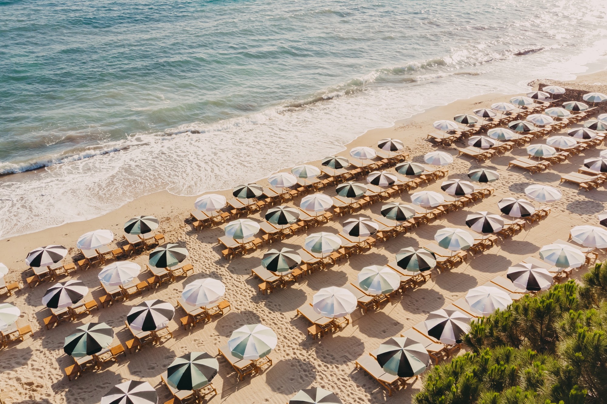 aerial view of striped umbrellas on a beach