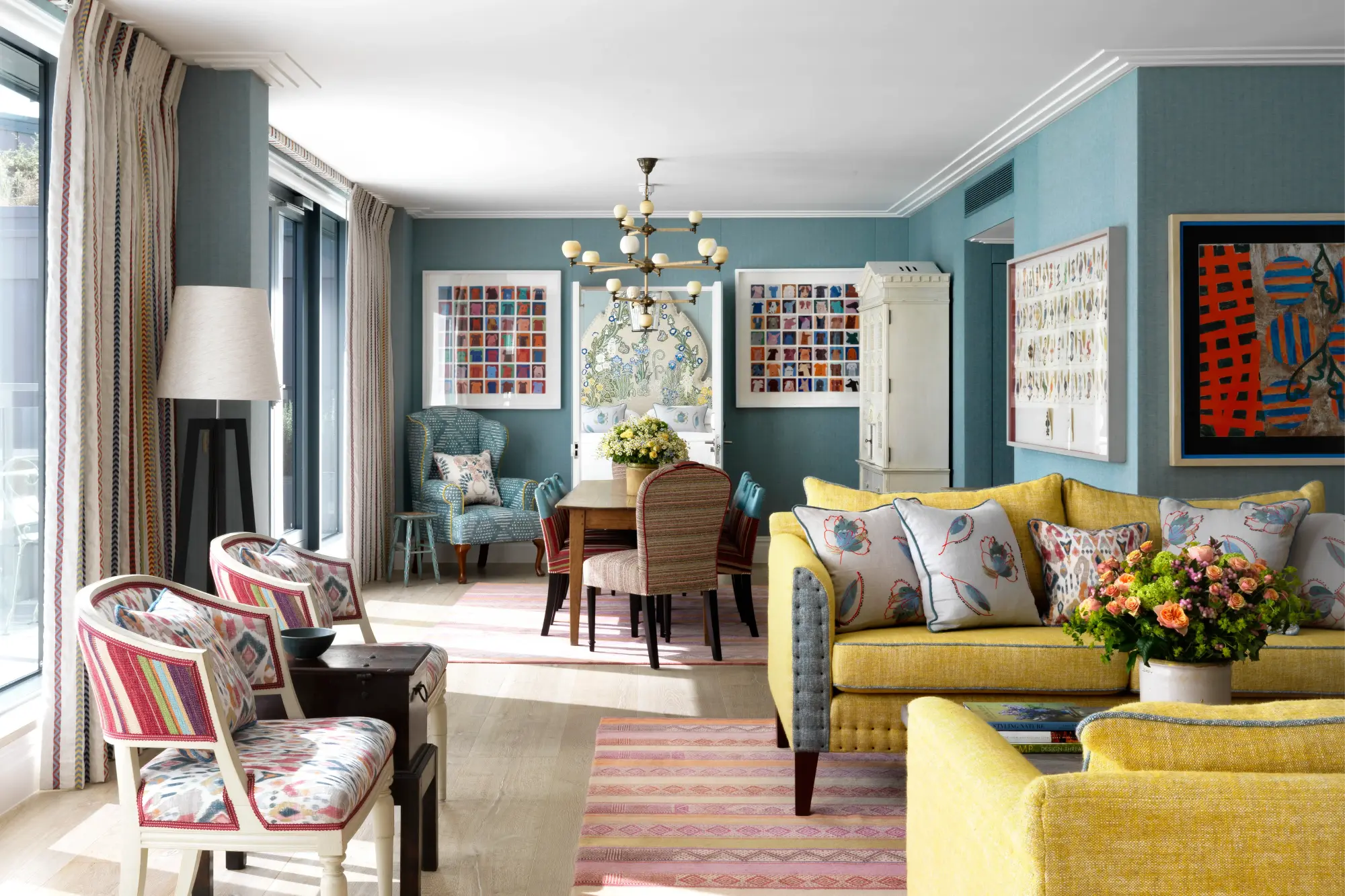 a colorful living room with a yellow sofas and blue walls