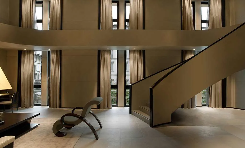 a sleek foyer with modern chairs and a white floating staircase