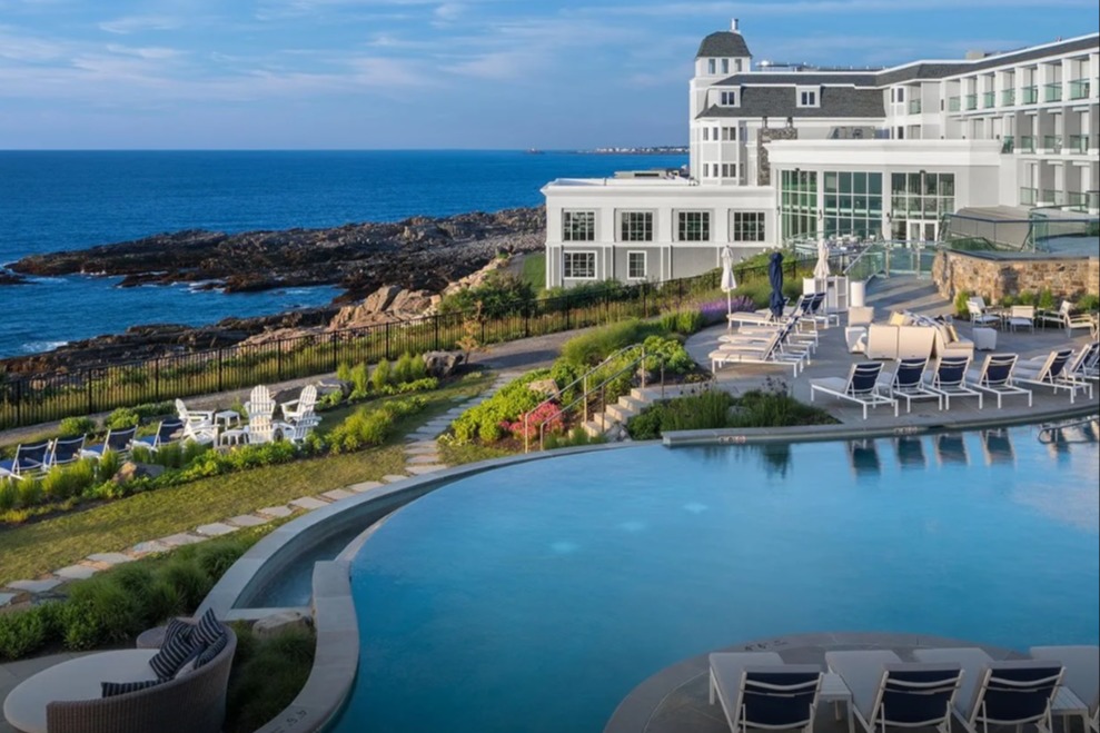 resort with white exterior and a pool overlooking a rocky coastline in Maine