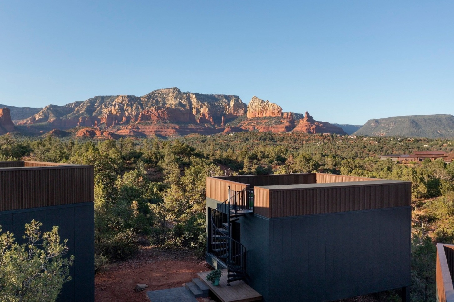 cube-shaped cabin in an Arizona landscape with red rocks in the distance