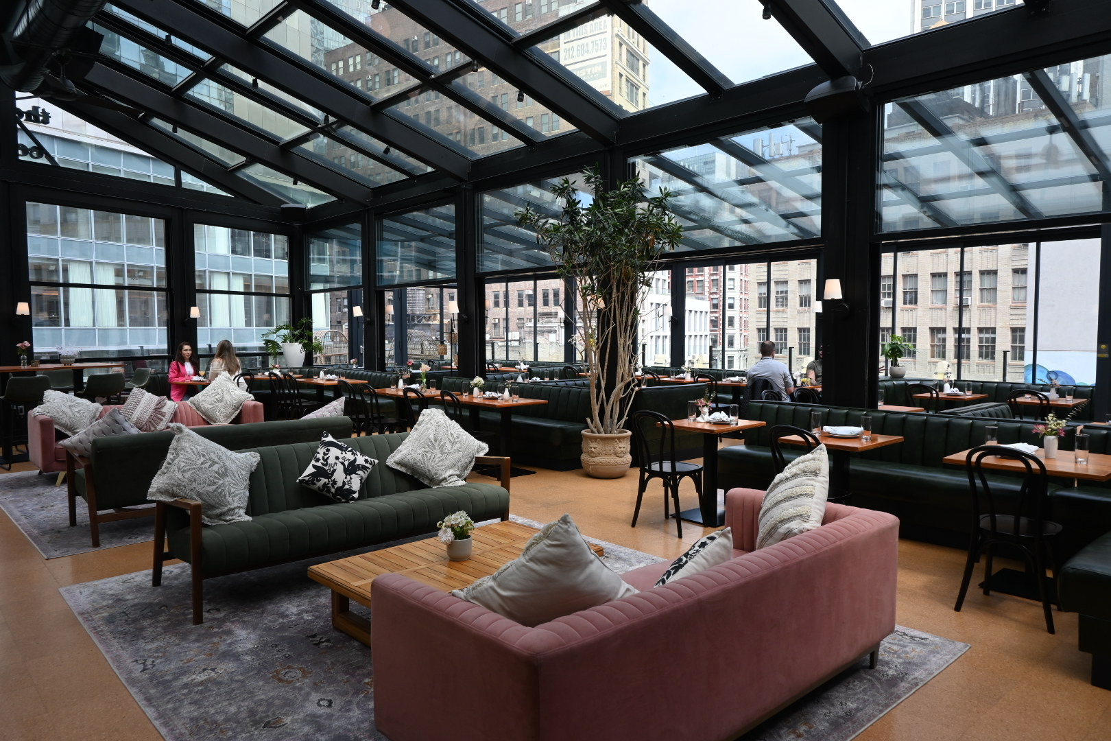 Lounge seating area in a restaurant with glass walls and ceilings.