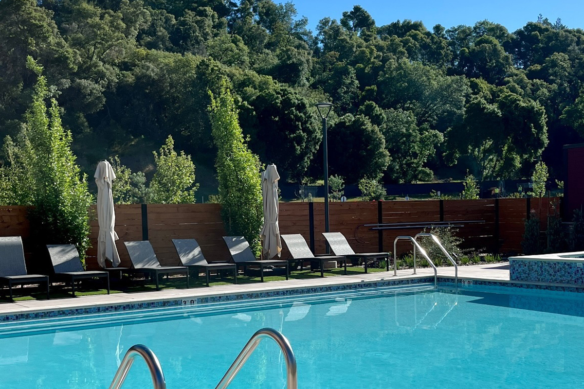 An outdoor swimming pool area with sun loungers around