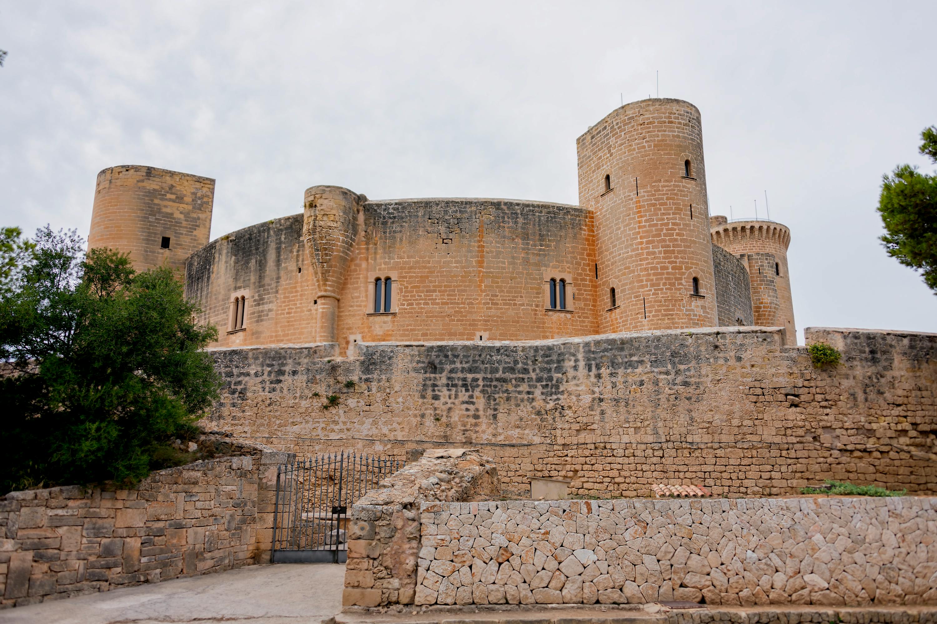 Castell de Bellver, a sand colored stone fortress is renowned for its unique circular design and panoramic views of the city and bay.