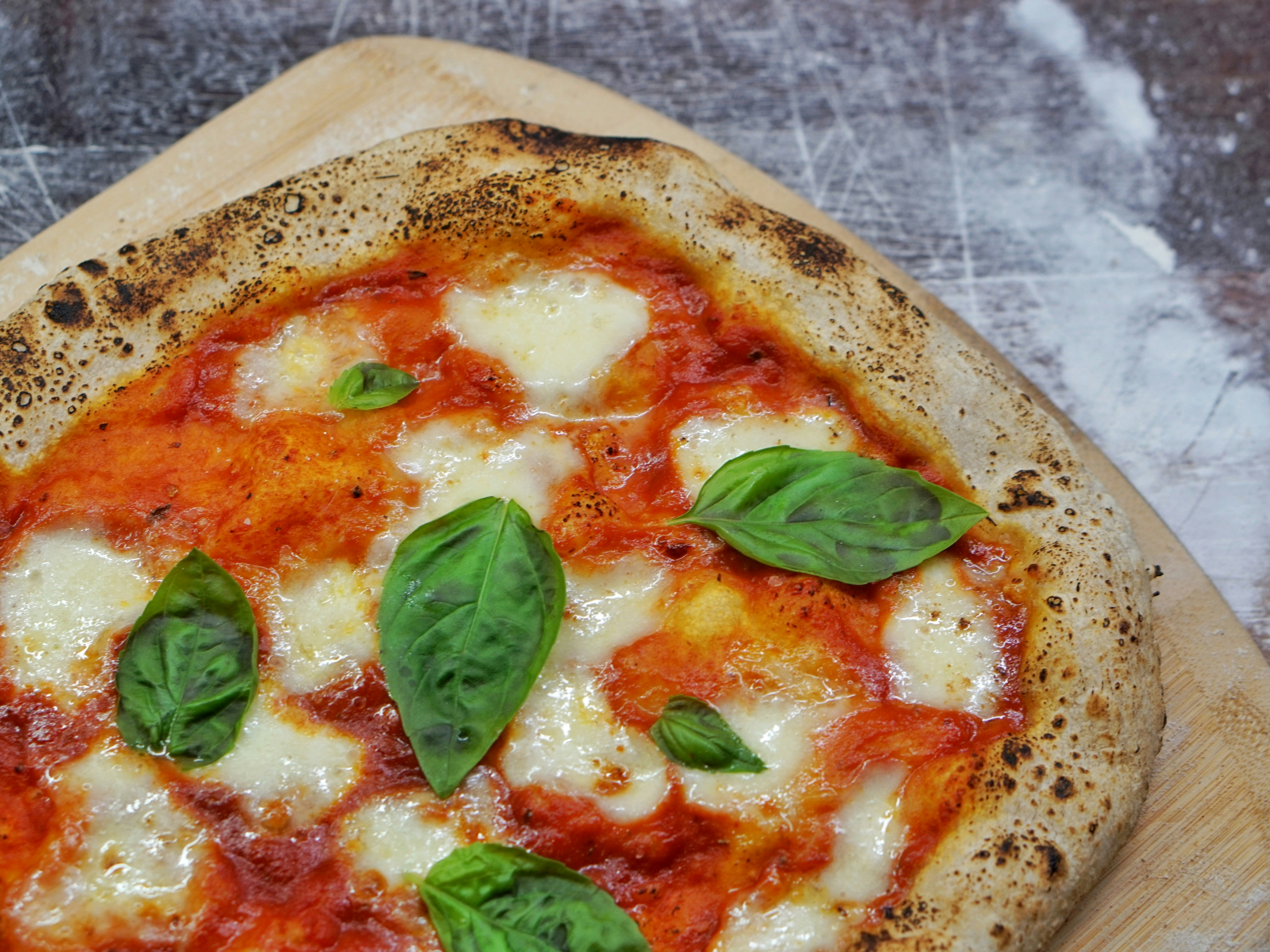 A fresh Italian pizza with cheese, pepperoni and basil sprinkled on top.