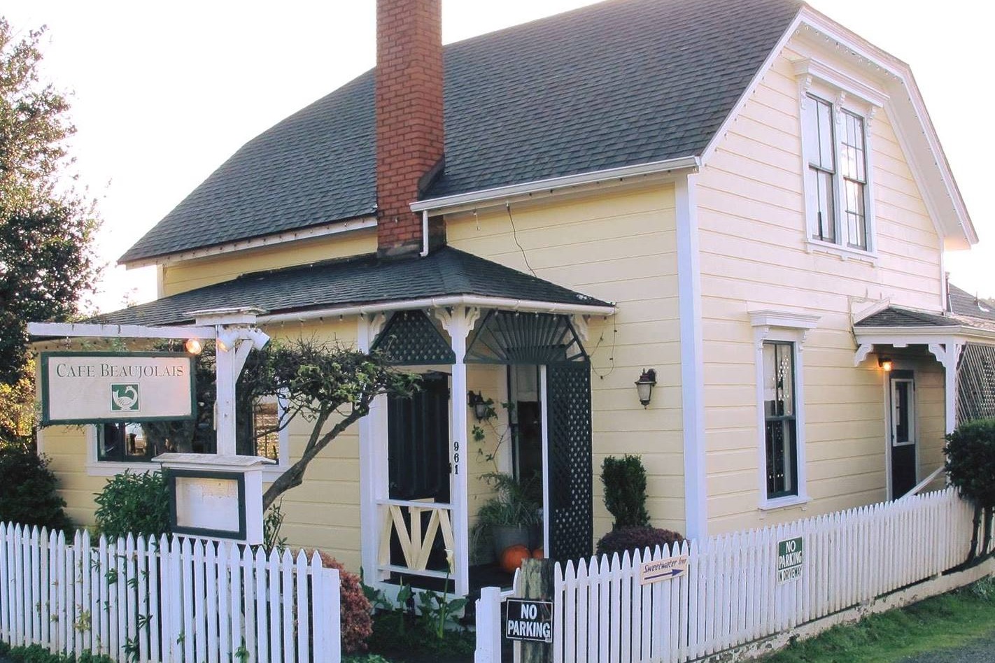 Café Beaujolais, a yellow 1893 Victorian farmhouse surrounded by a white picket fence.