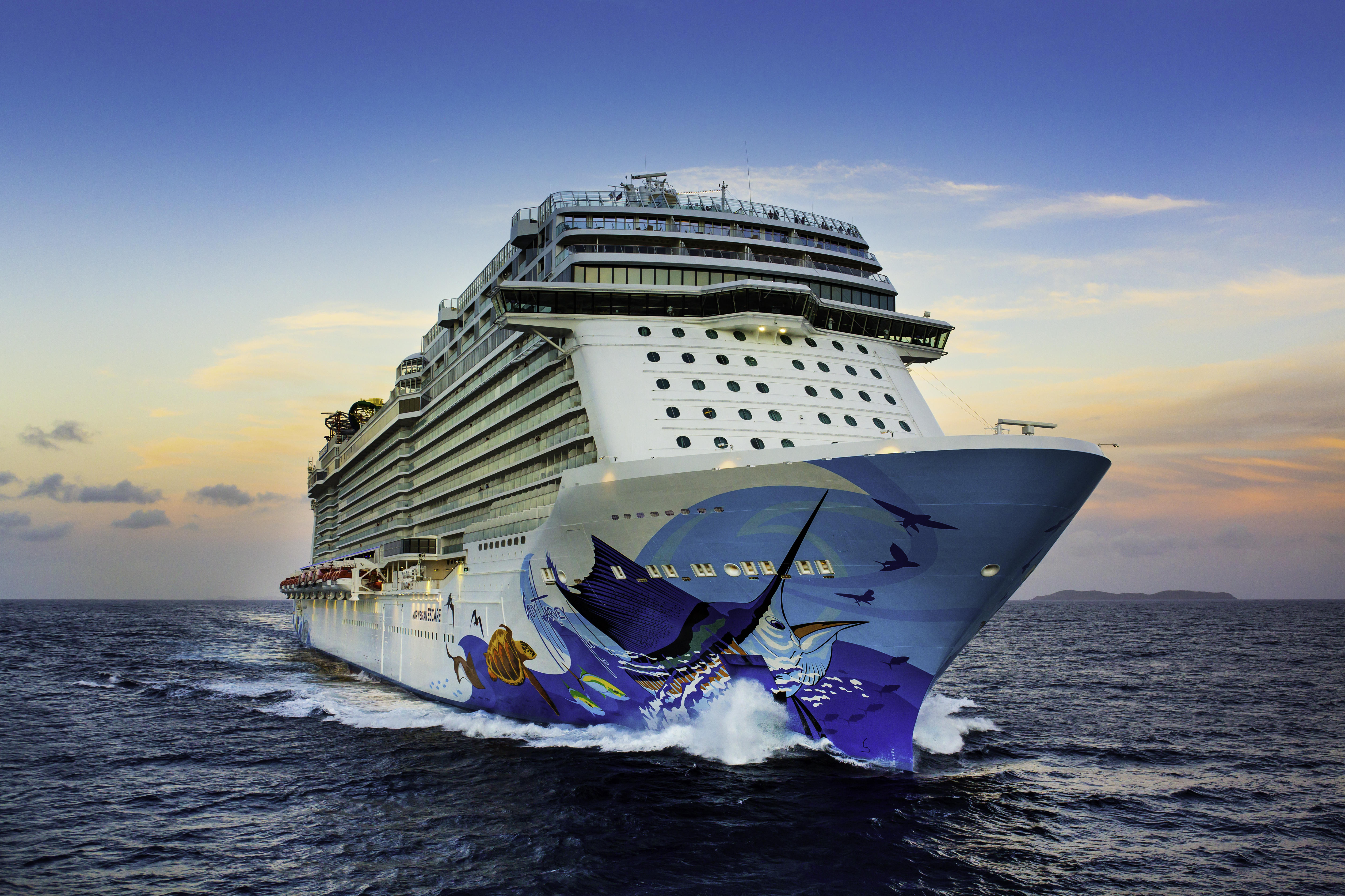 A photo of he NCL (Norwegian Cruise Line) ship on the open sea at sunset.