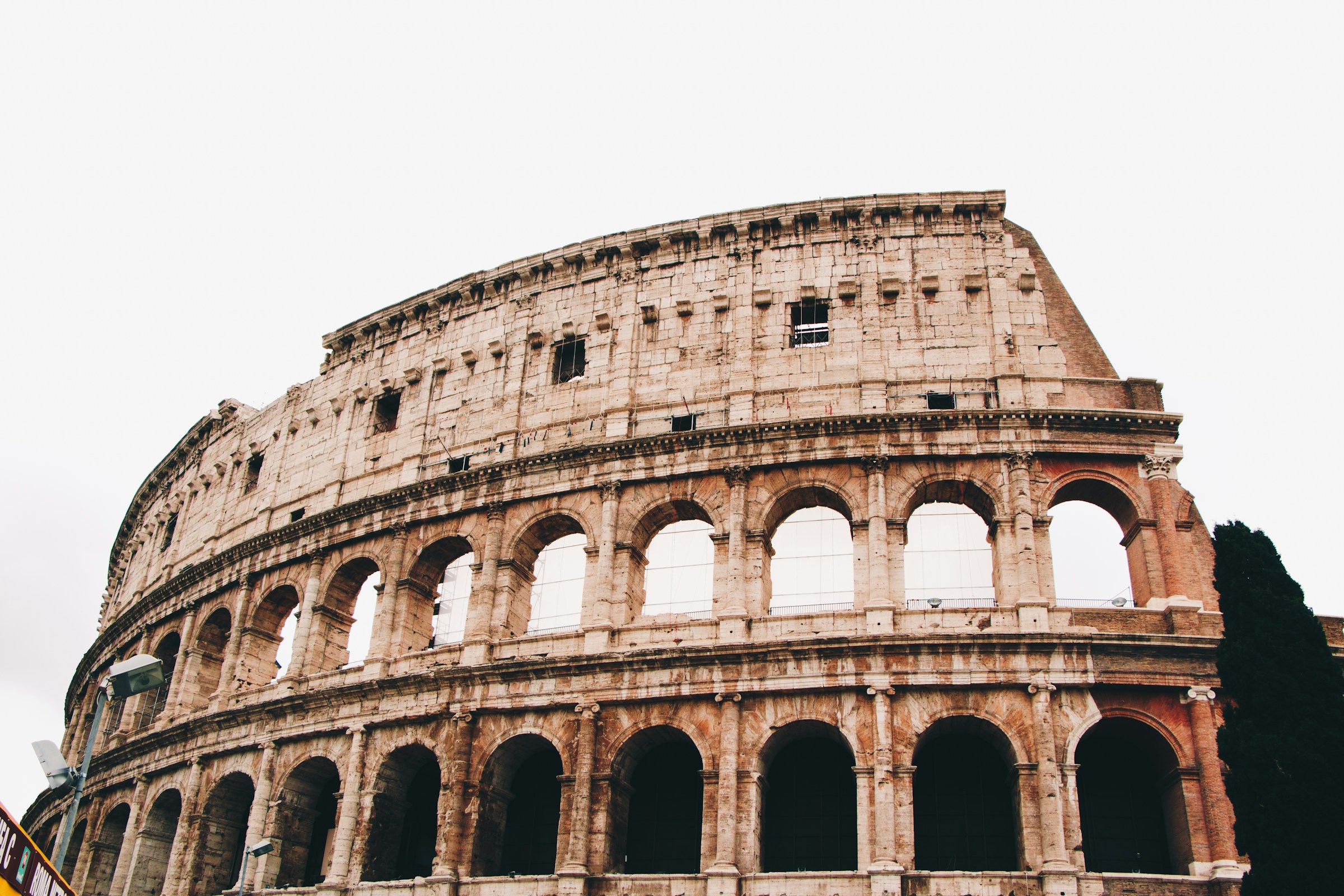 View of the Colosseum from below under an overcast sky.