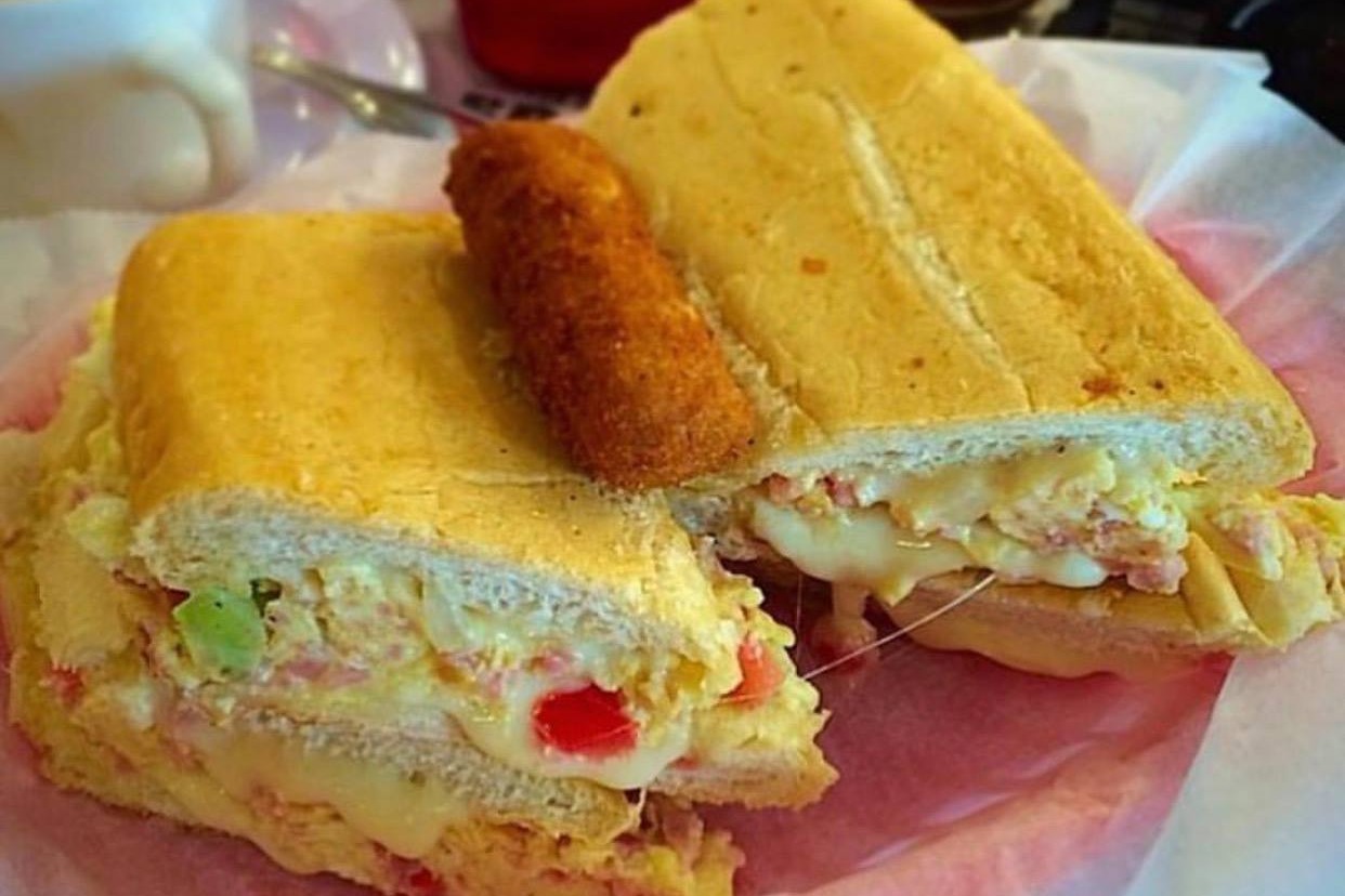 A pressed sandwich on parchment paper on a plate