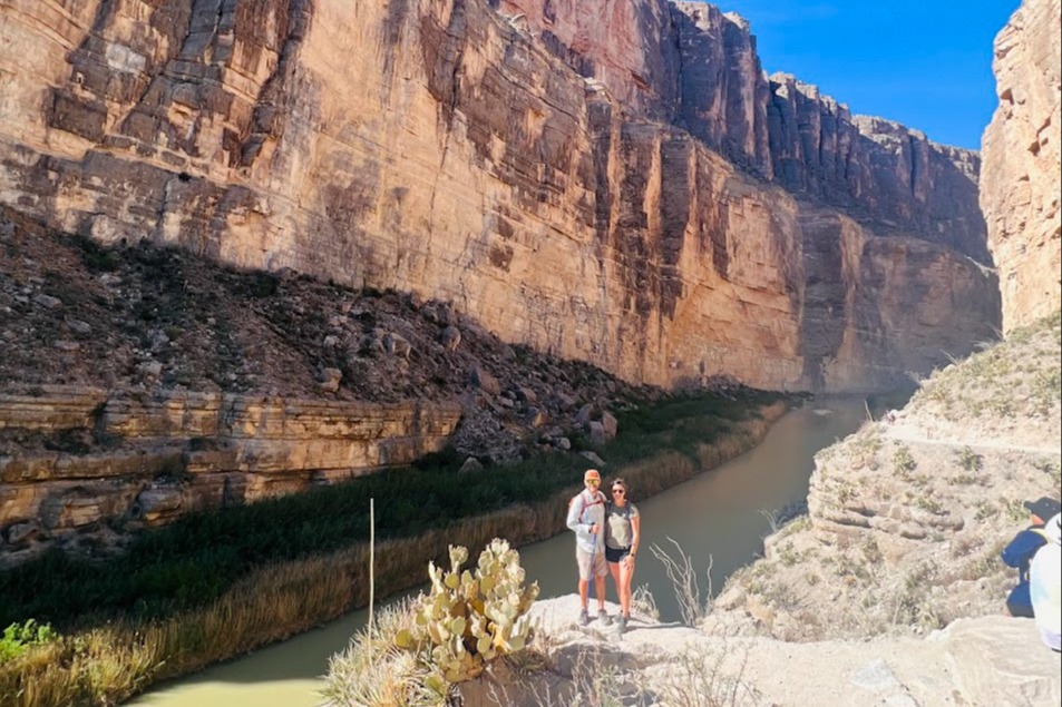 Couple posing for a photo next to a mountainside