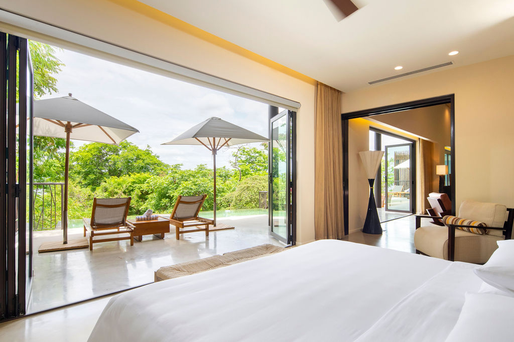 white bed overlooking a terrace overlooking the jungle